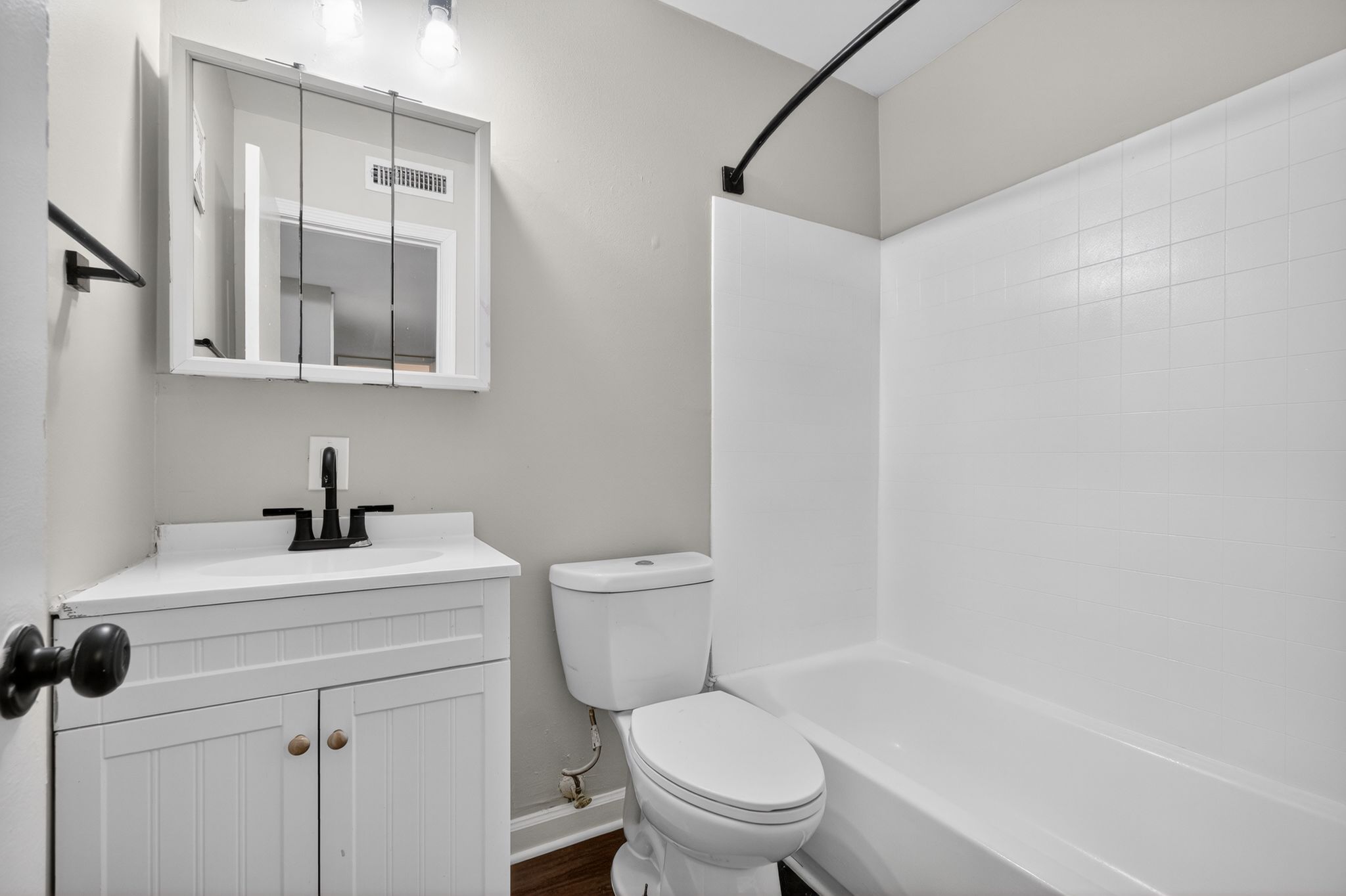 A white bathroom with a toilet, sink, and bathtub.
