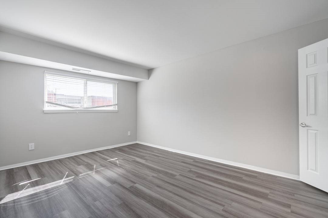 A room with a window and wooden flooring.