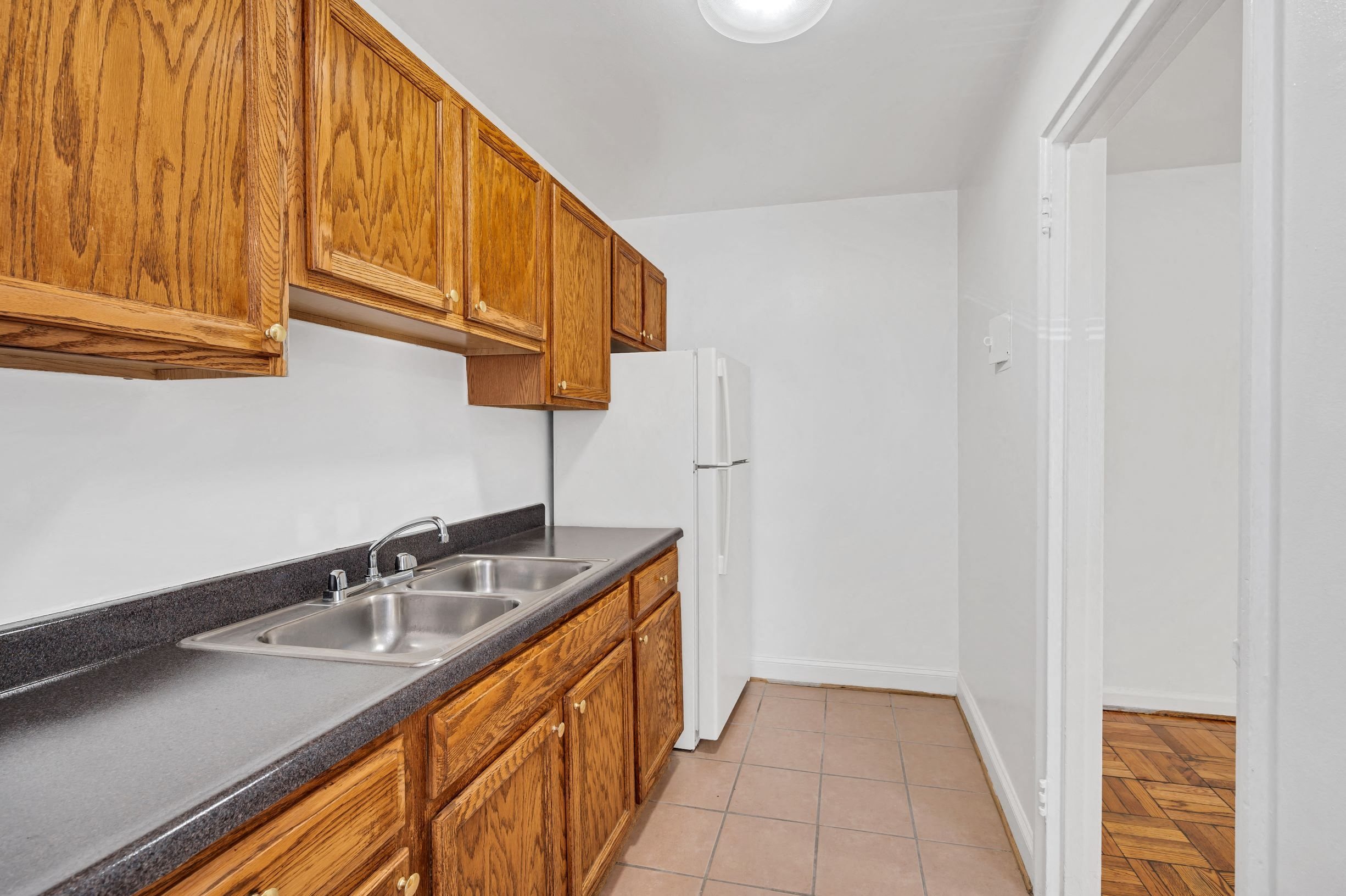 A kitchen with wooden cabinets and a white refrigerator.