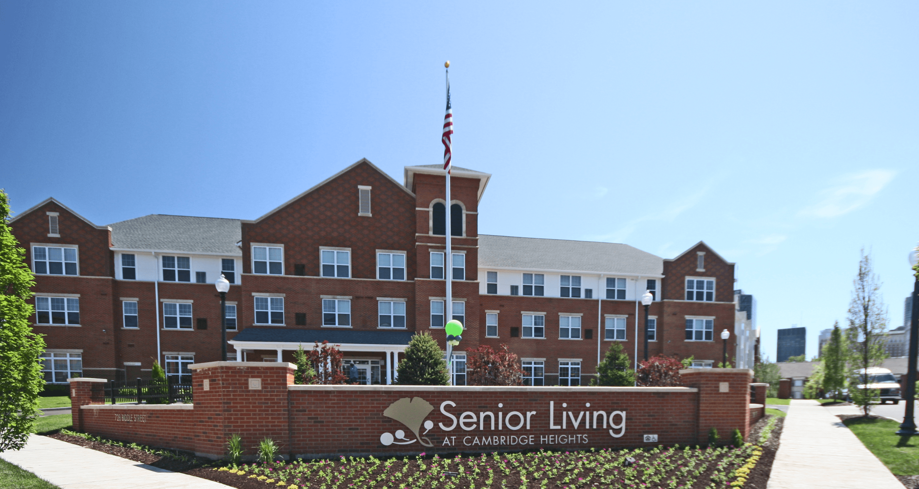 a large brick building with an flag on top of it and a sign