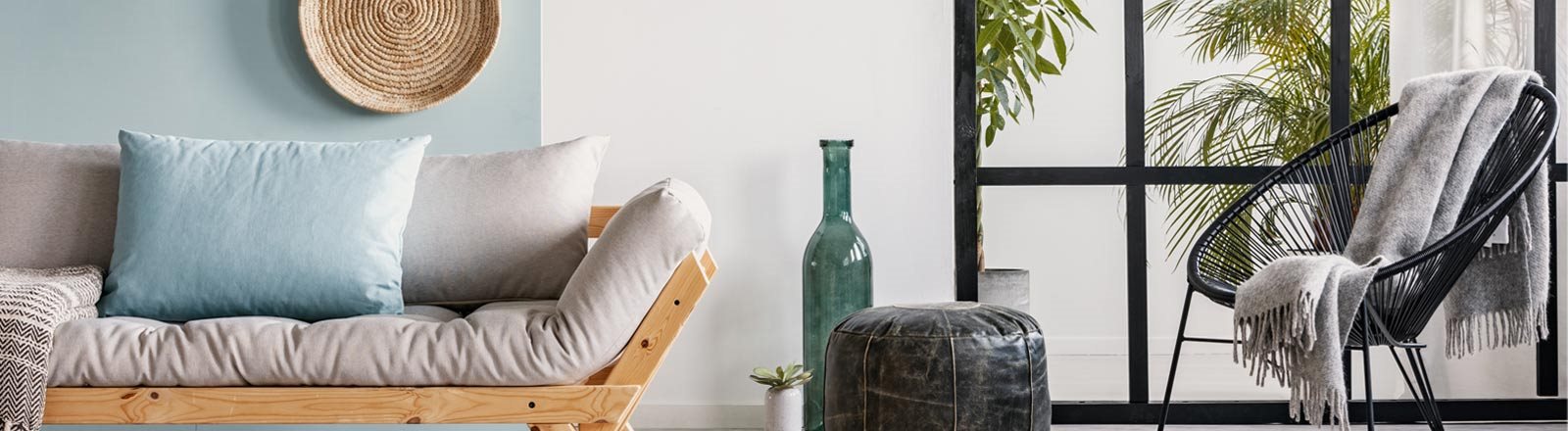 A living room with a couch, a chair, a table, and a plant.