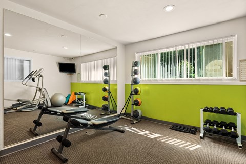 a workout room with a green wall and gym equipment