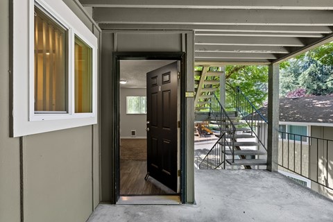 the view of the front door from the porch of a home with a stairwell