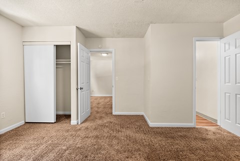 an empty room with white doors and a carpeted floor