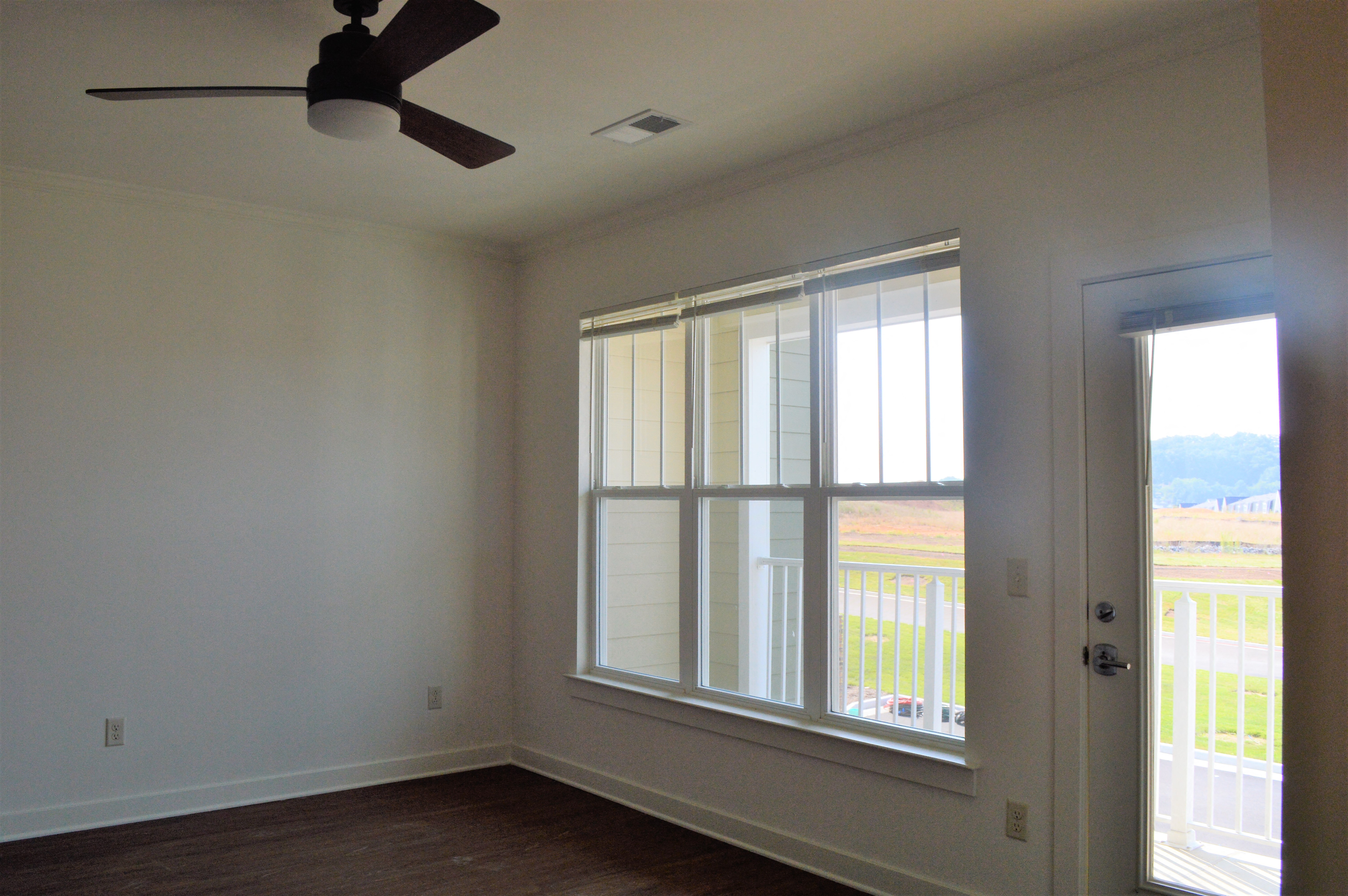 Bedroom with window, balcony access, and ceiling fan