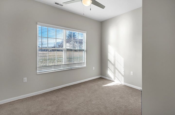 A room with a window and a ceiling fan.