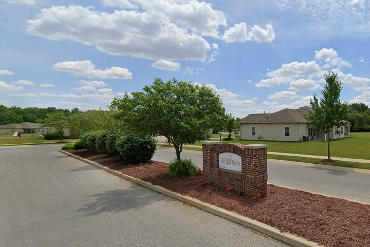 A sign in front of a building that says "Welcome to the community".
