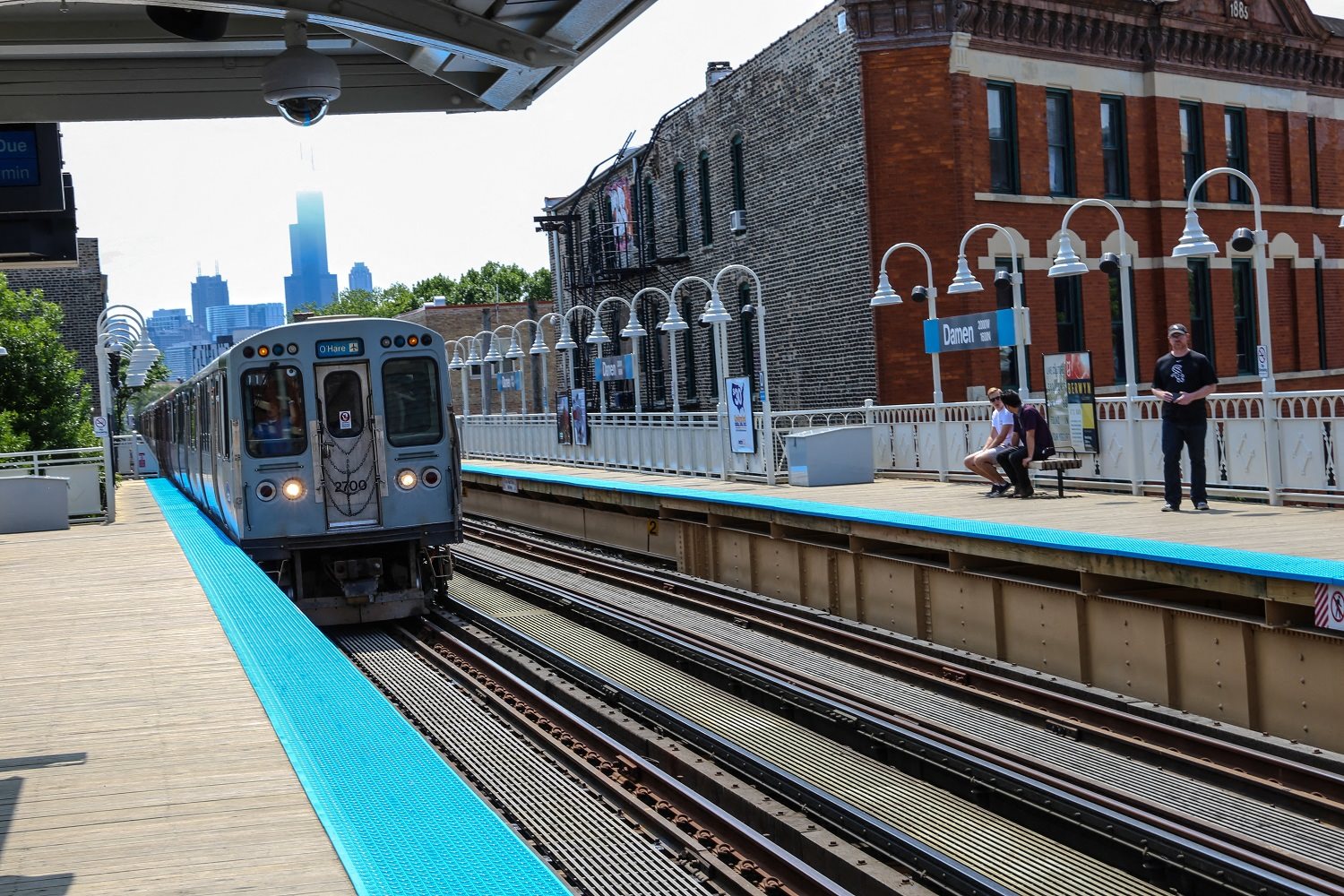 a train pulling into the station with the chicago skyline in the background