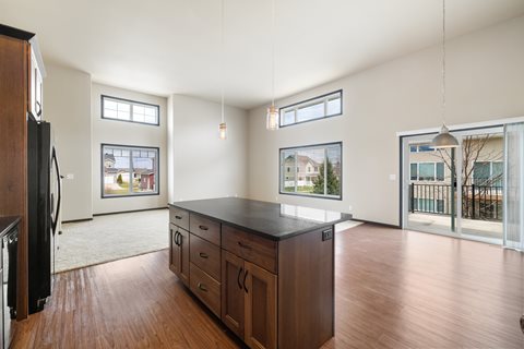 A kitchen with wooden floors and a black countertop.