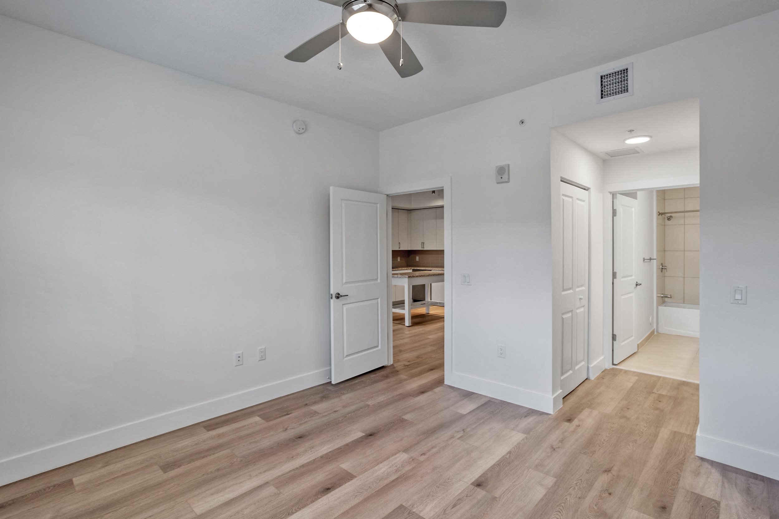 a bedroom with hardwood flooring and a ceiling fan