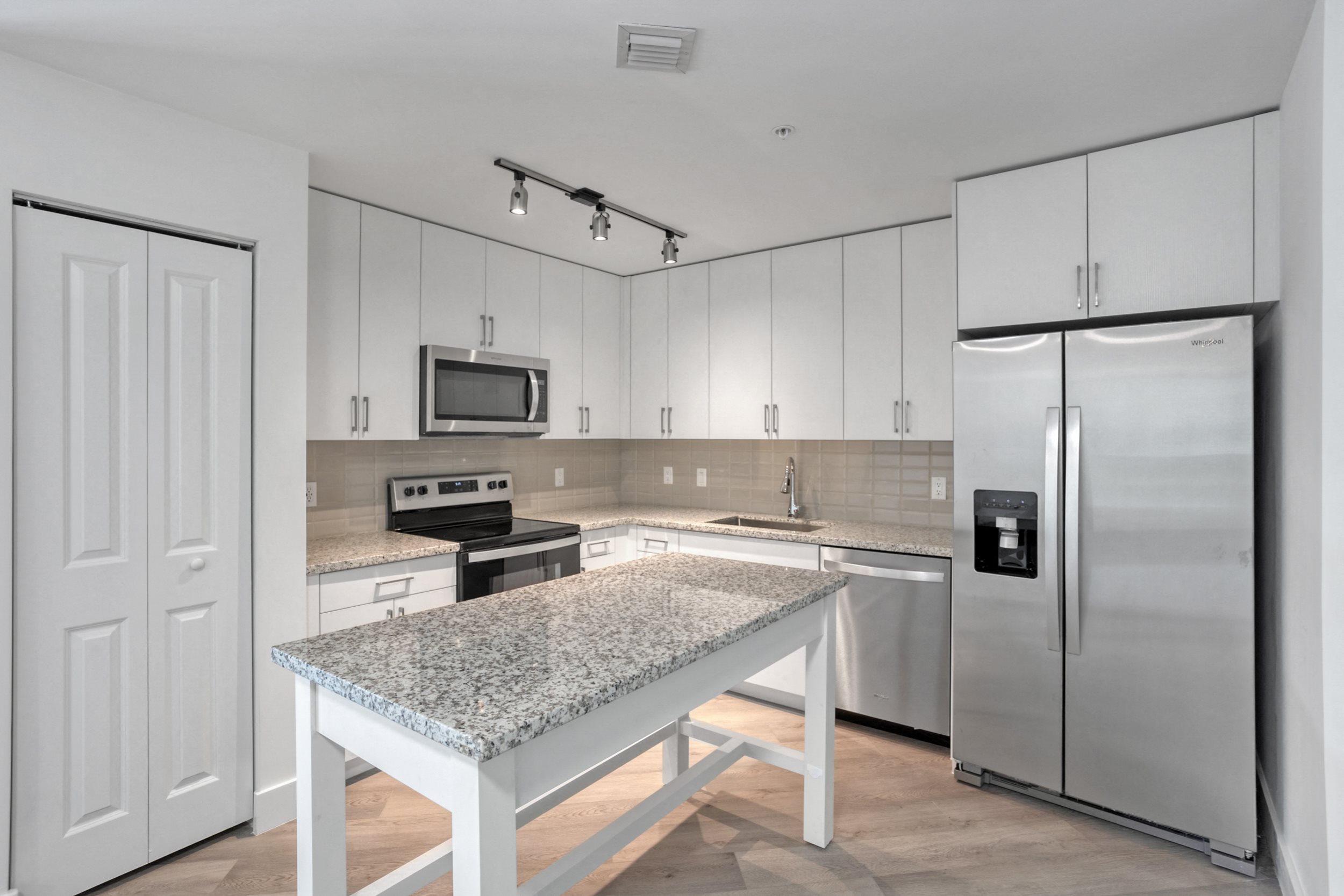 a kitchen with white cabinets and a granite counter top