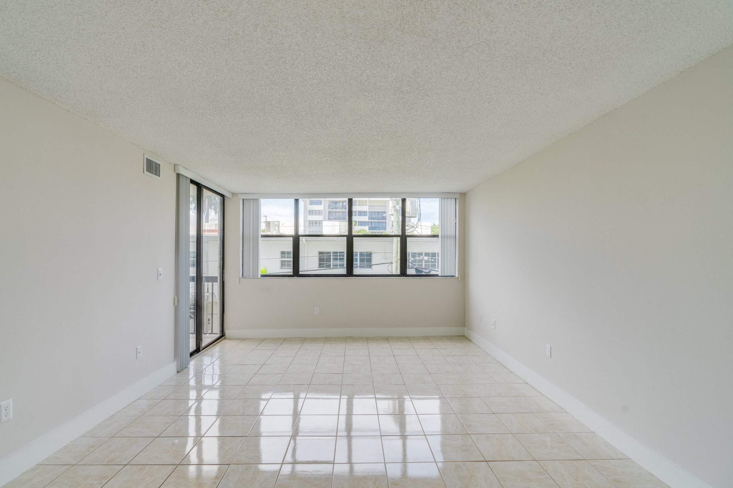 the living room of an empty apartment with a large window
