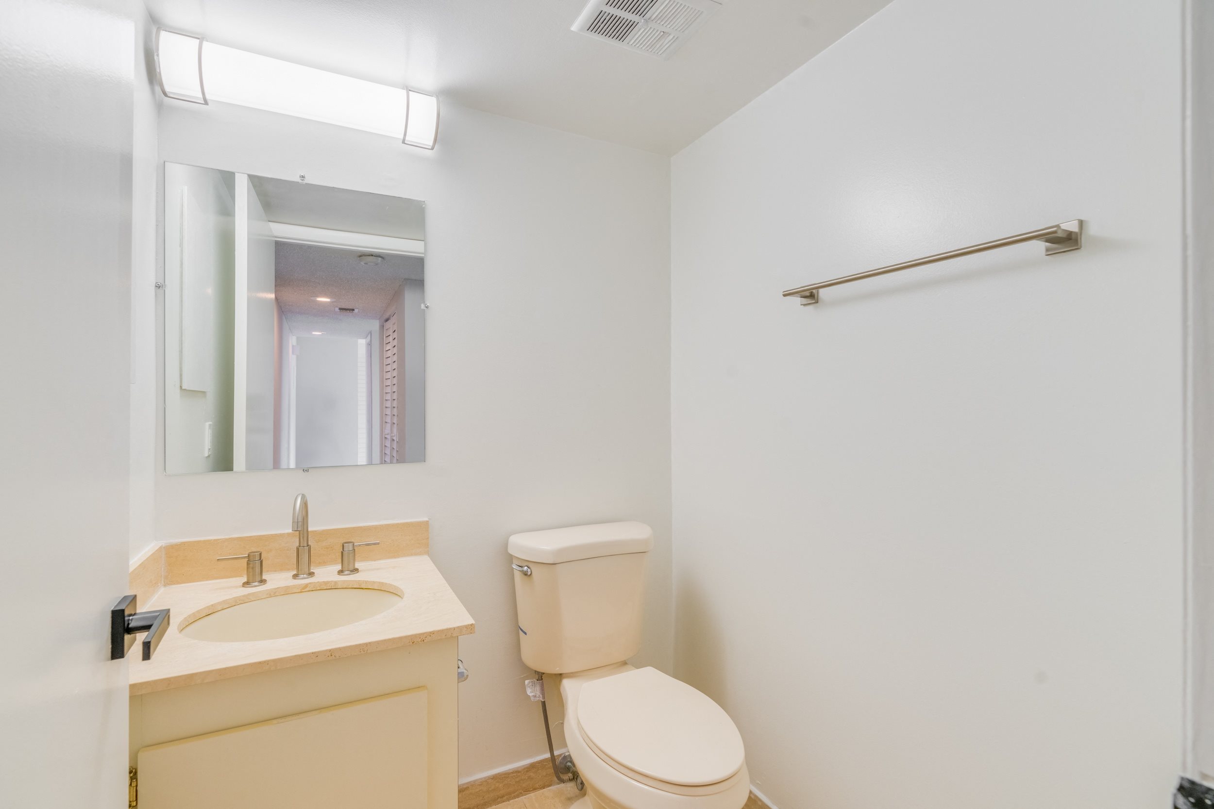 a bathroom with a toilet and a sink and a mirror