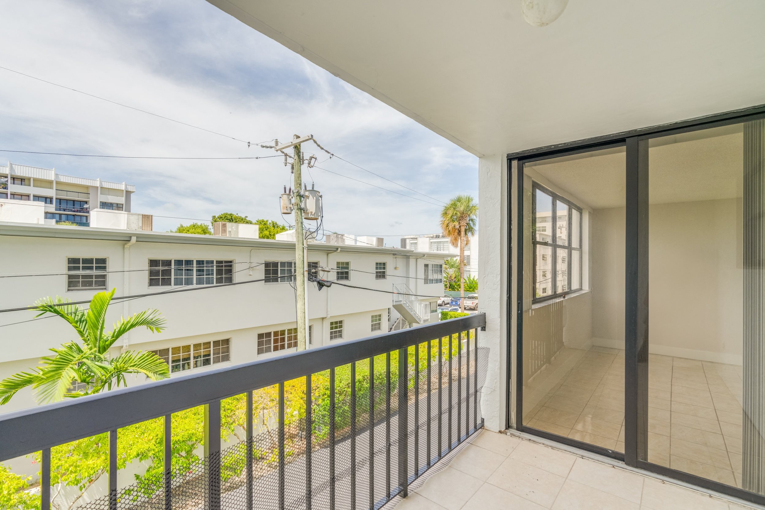 a balcony with a view of a building and a glass door