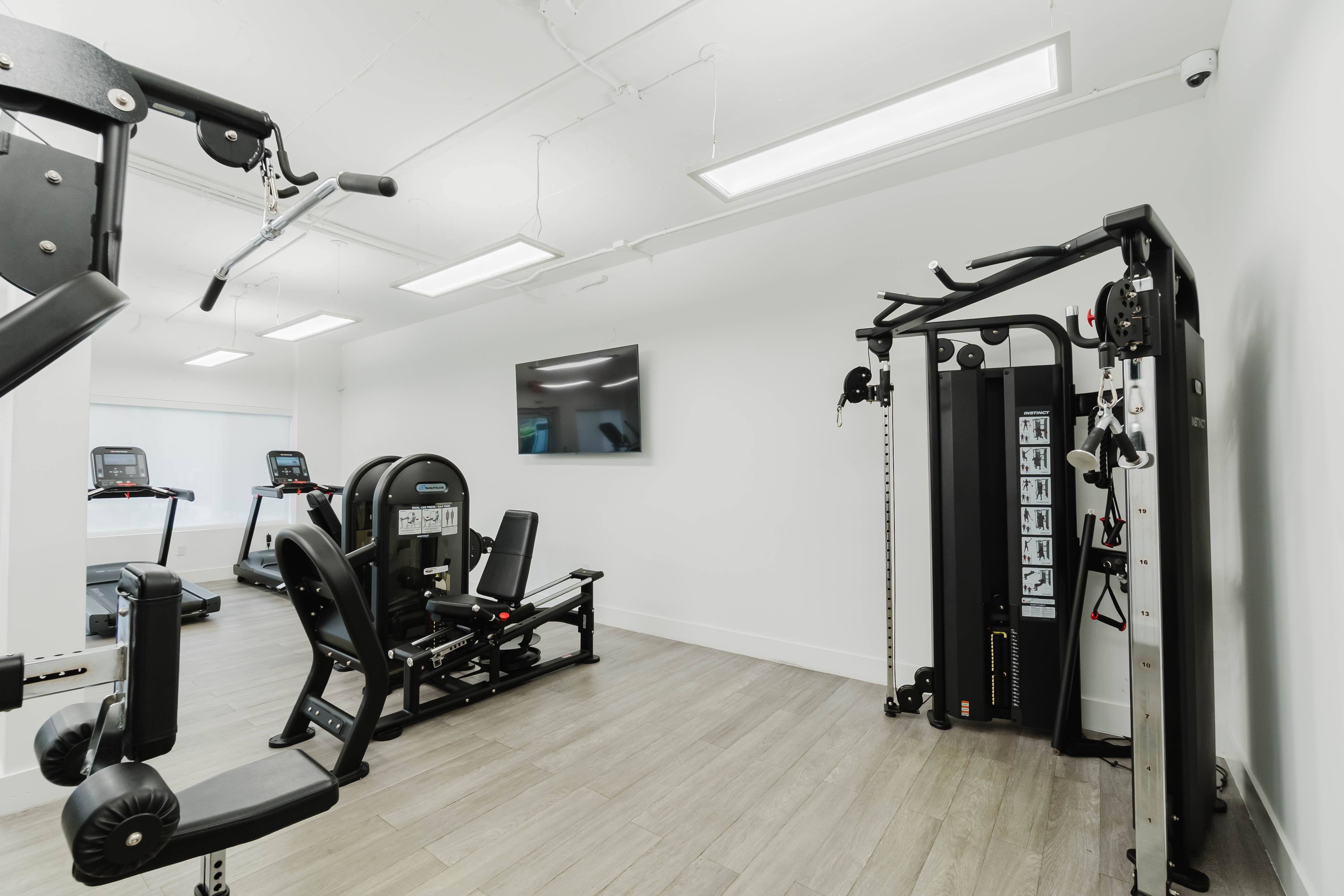 A gym with a variety of equipment including a leg press machine.