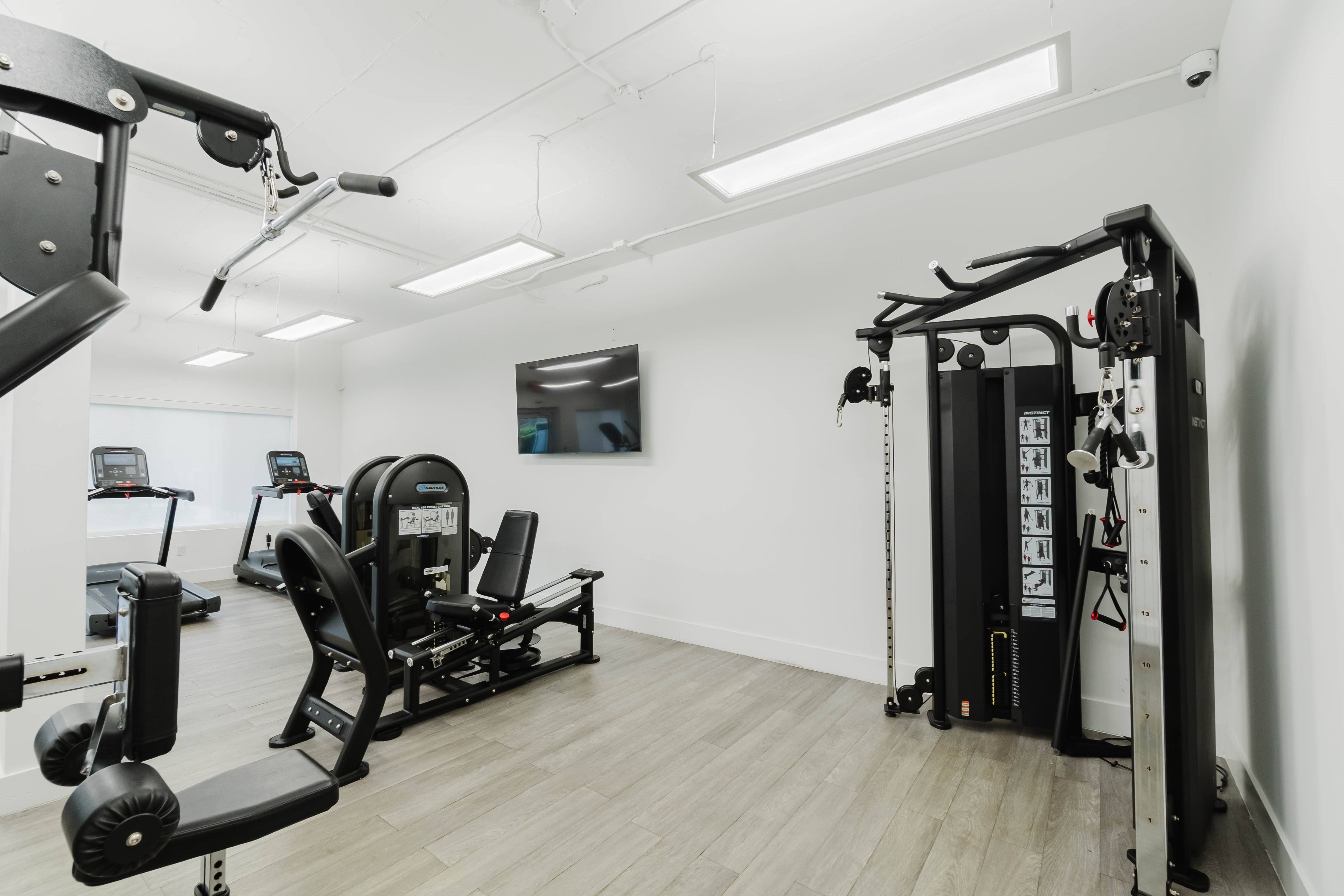 A gym with a variety of equipment including a leg press machine.