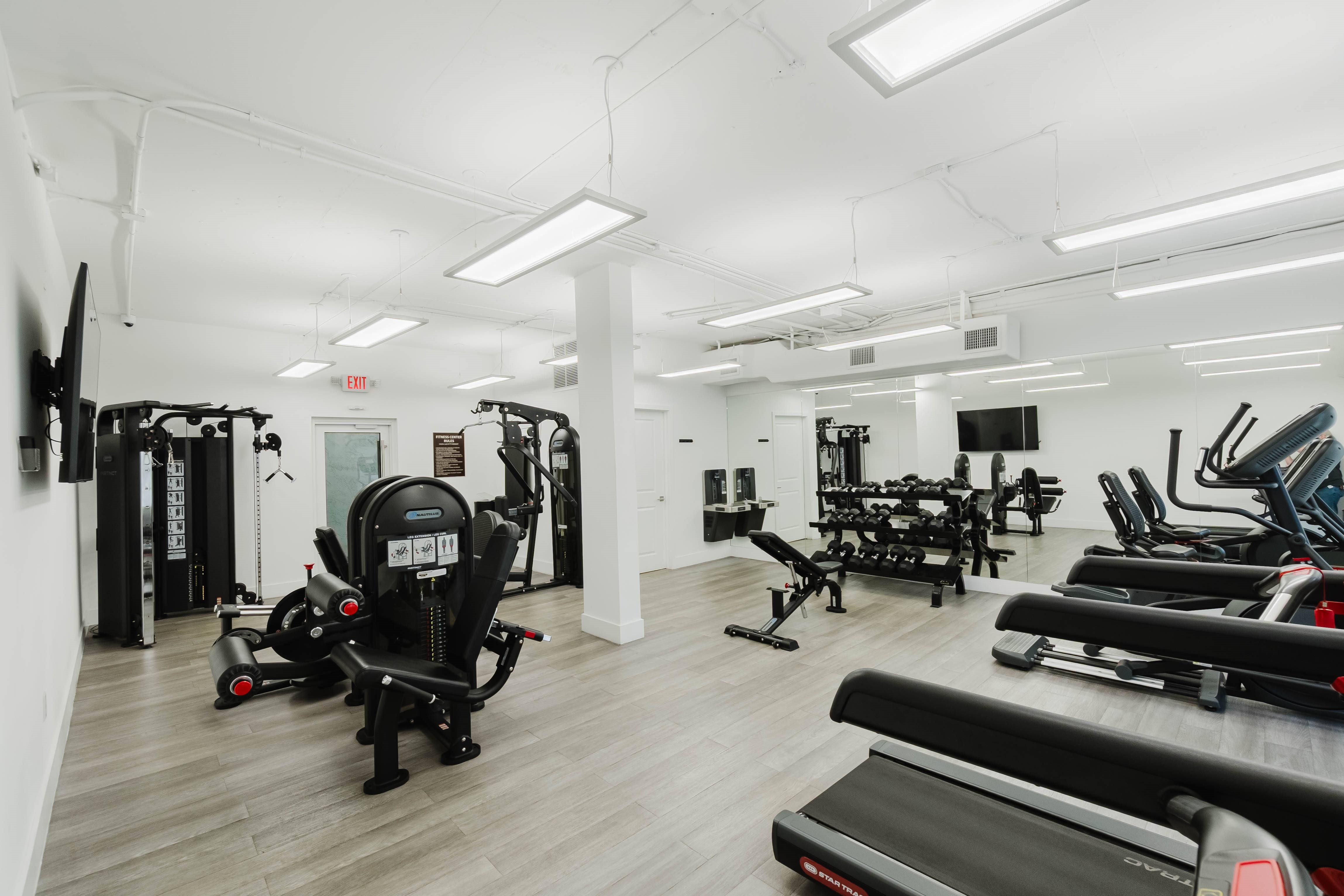 A gym with treadmills, weights, and other exercise equipment.