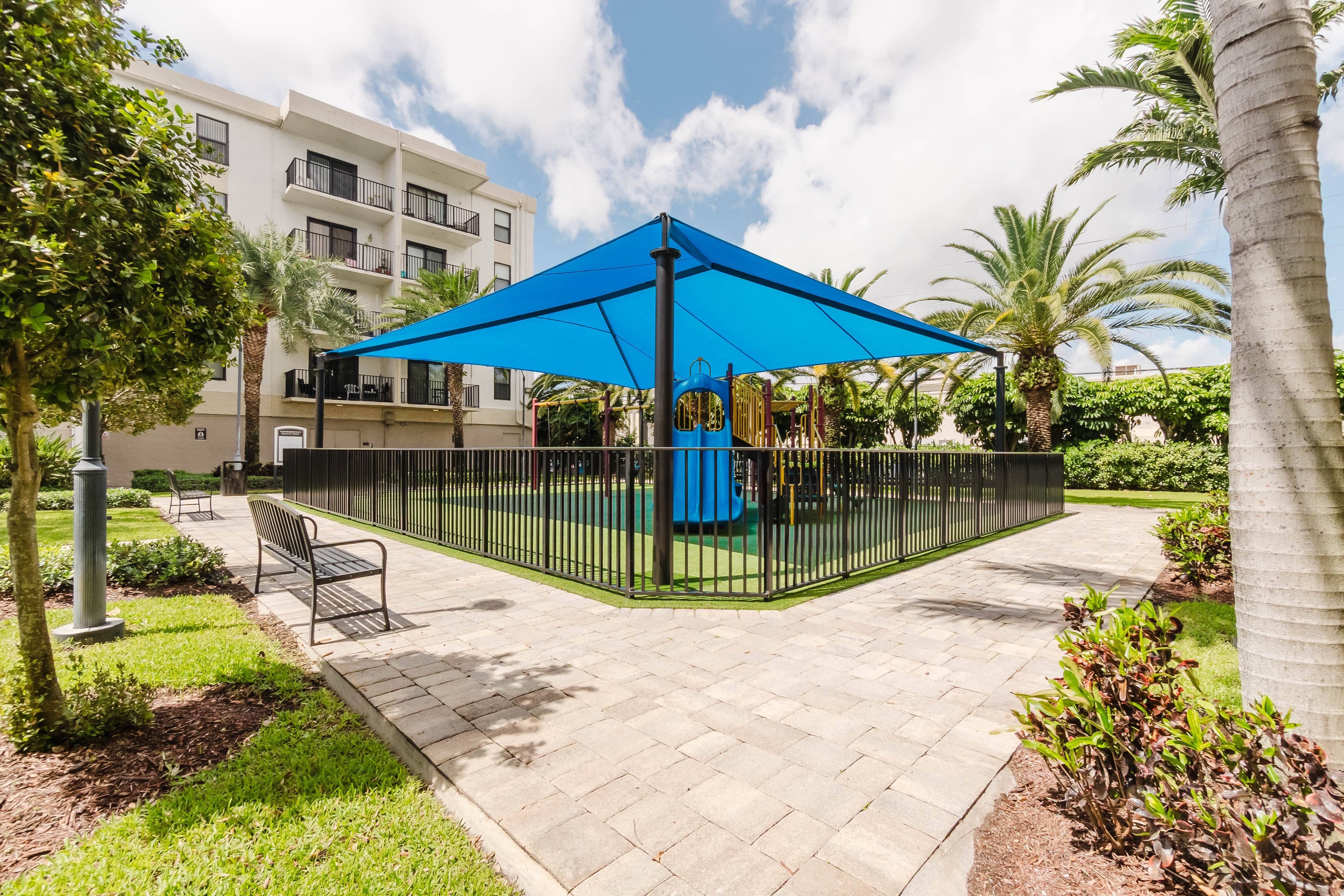 A blue canopy is over a bench and a table.