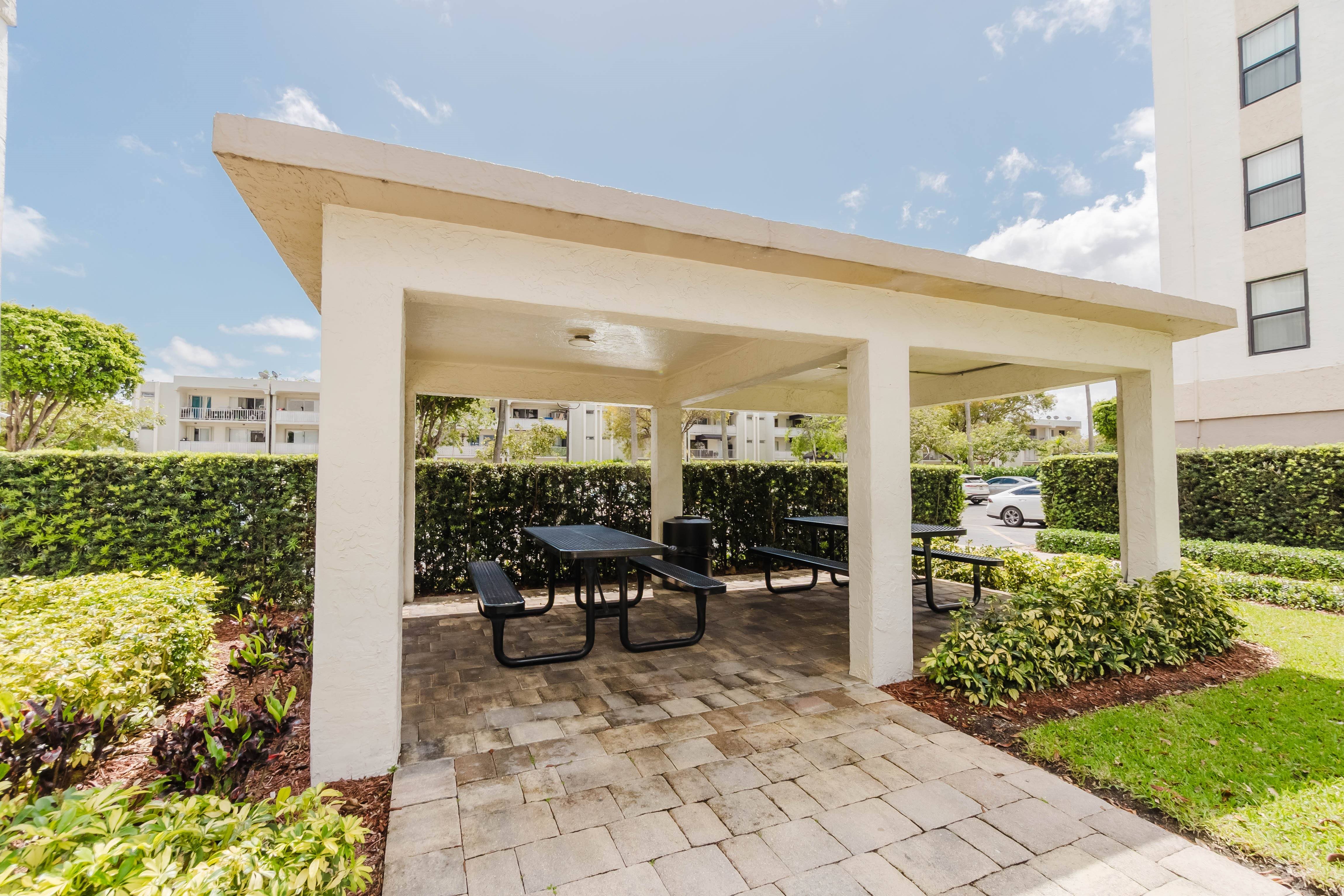 A patio with a table and chairs under a white overhang.
