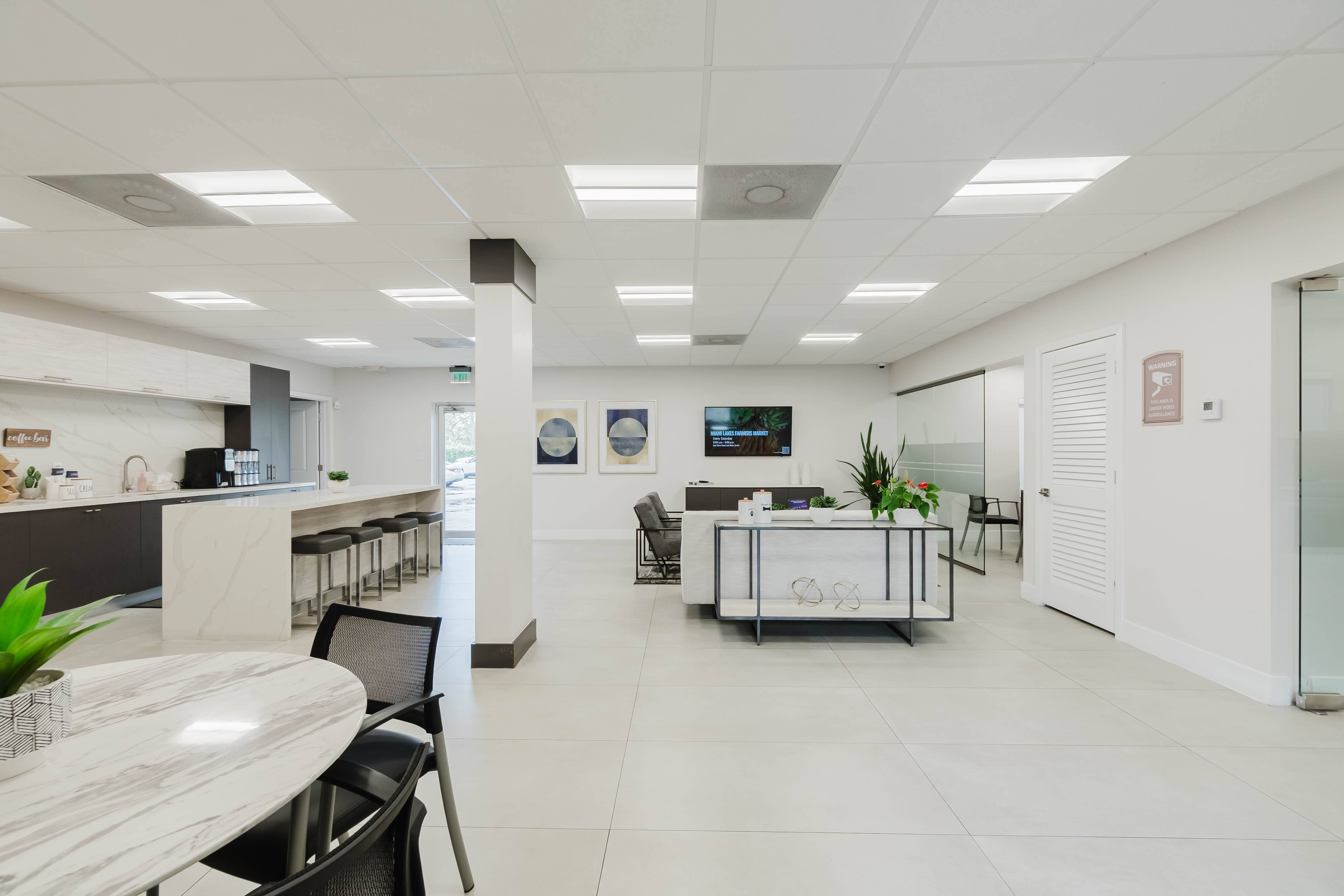 A modern office space with a white color scheme and a variety of furniture.