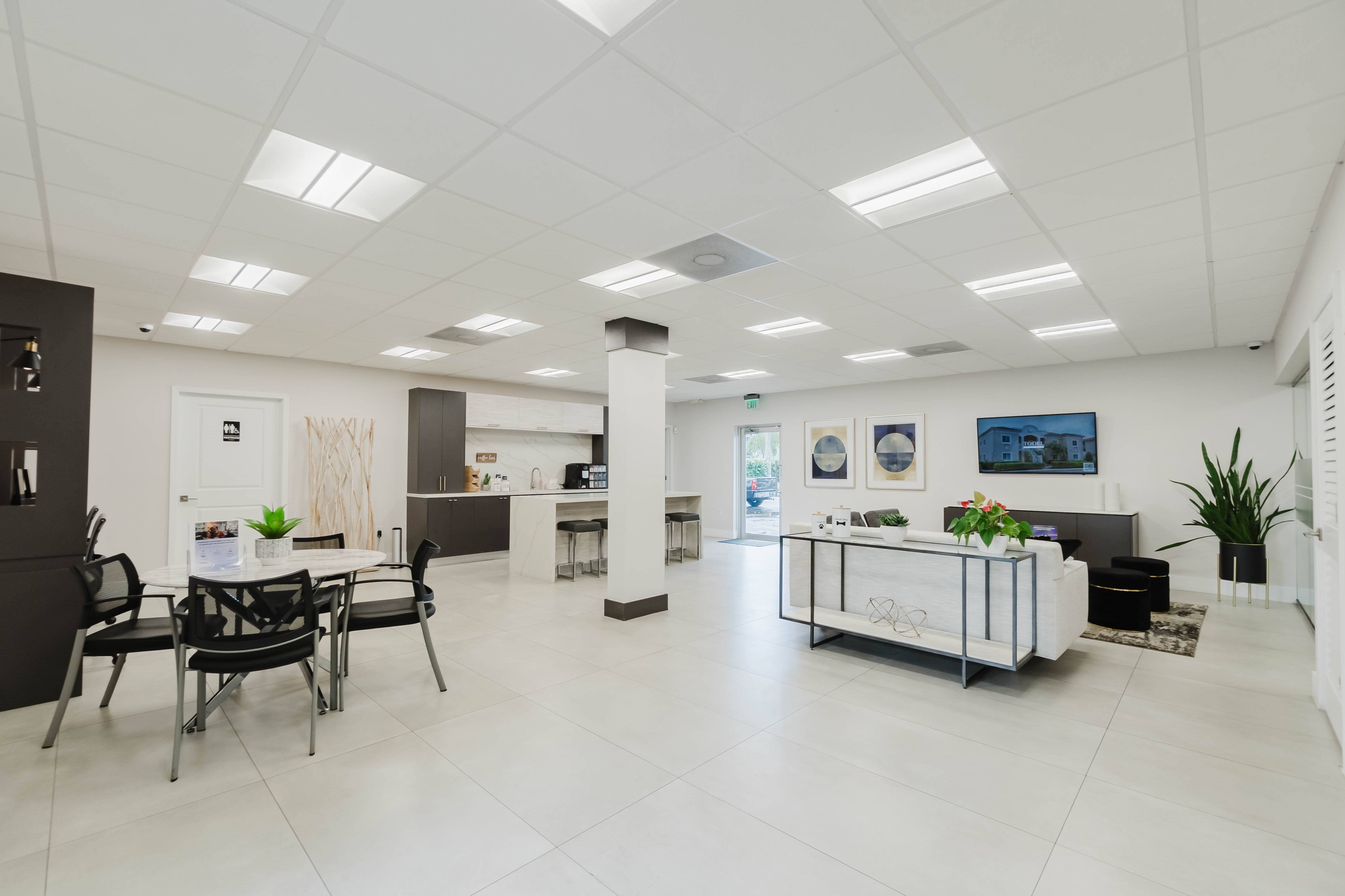 A spacious office with a white interior and a long table with chairs.