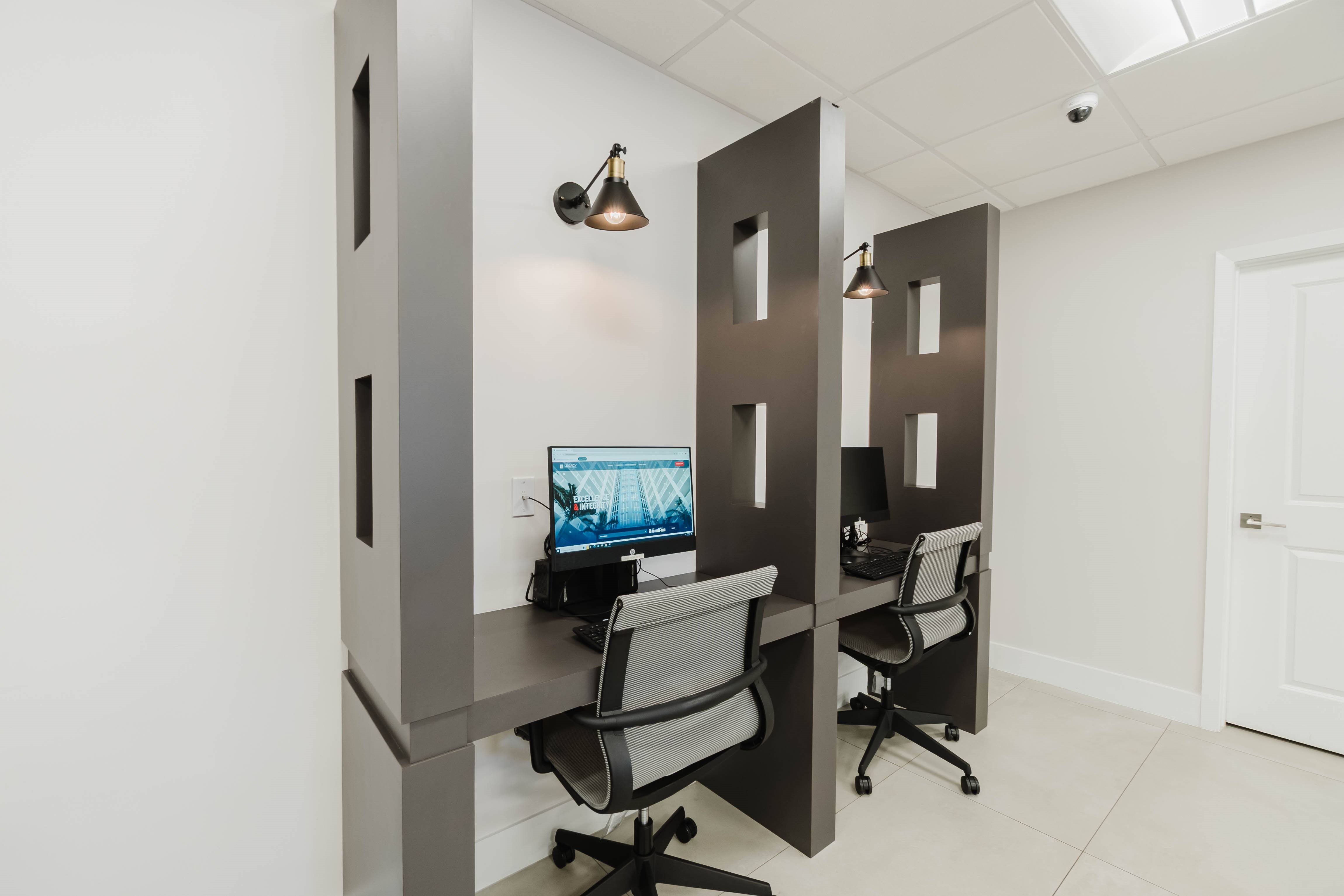 A modern office with a computer on a desk and a chair.
