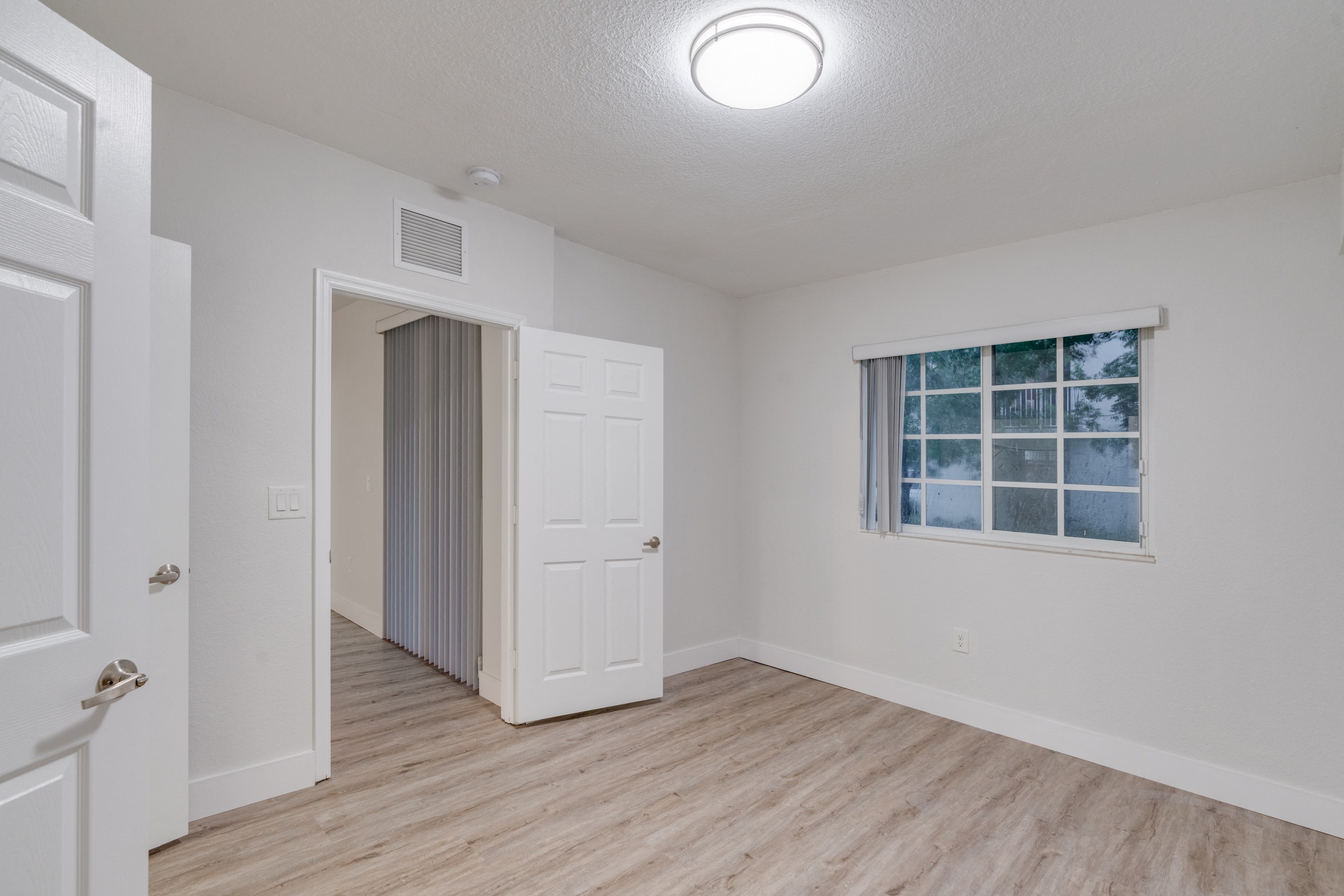an empty living room with white walls and wood flooring