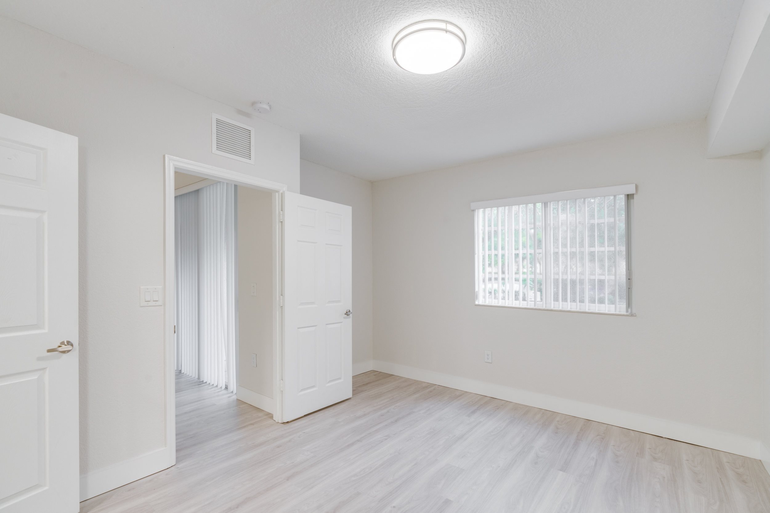 an empty room with a door to a closet and a window