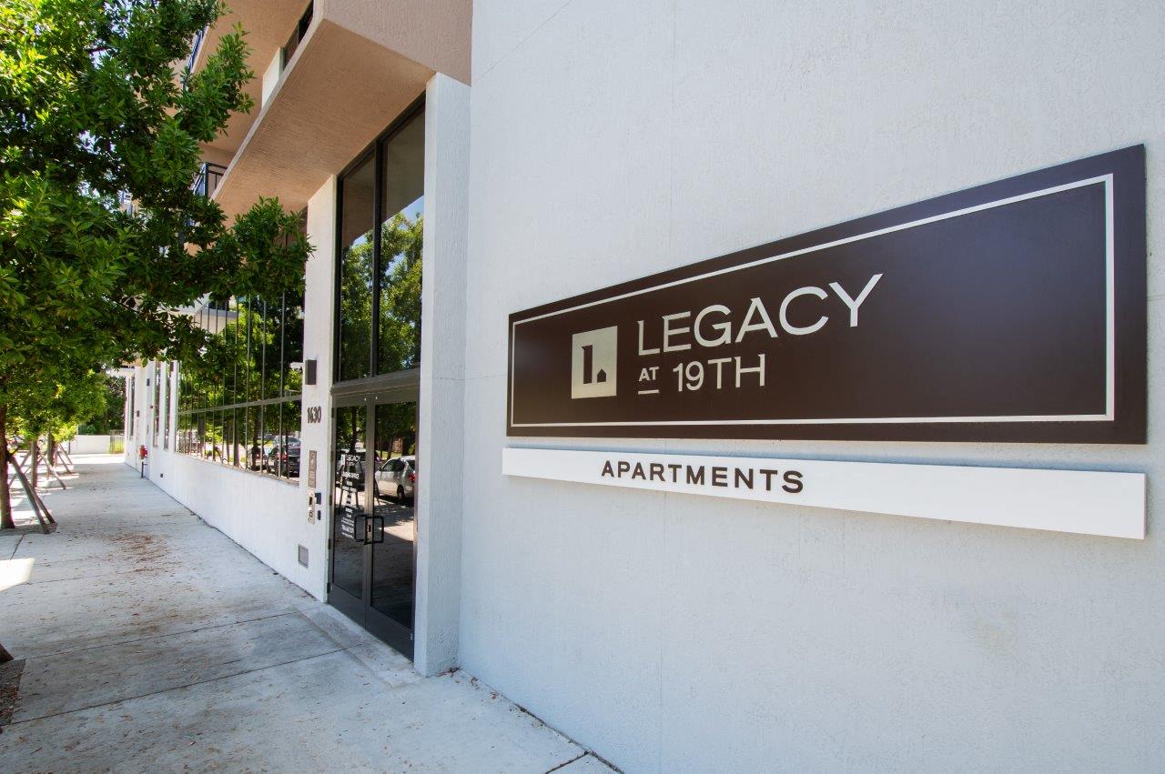 a sign for legacy apartments on the side of a building