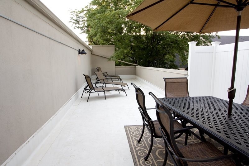 A patio with a table and chairs under an umbrella.