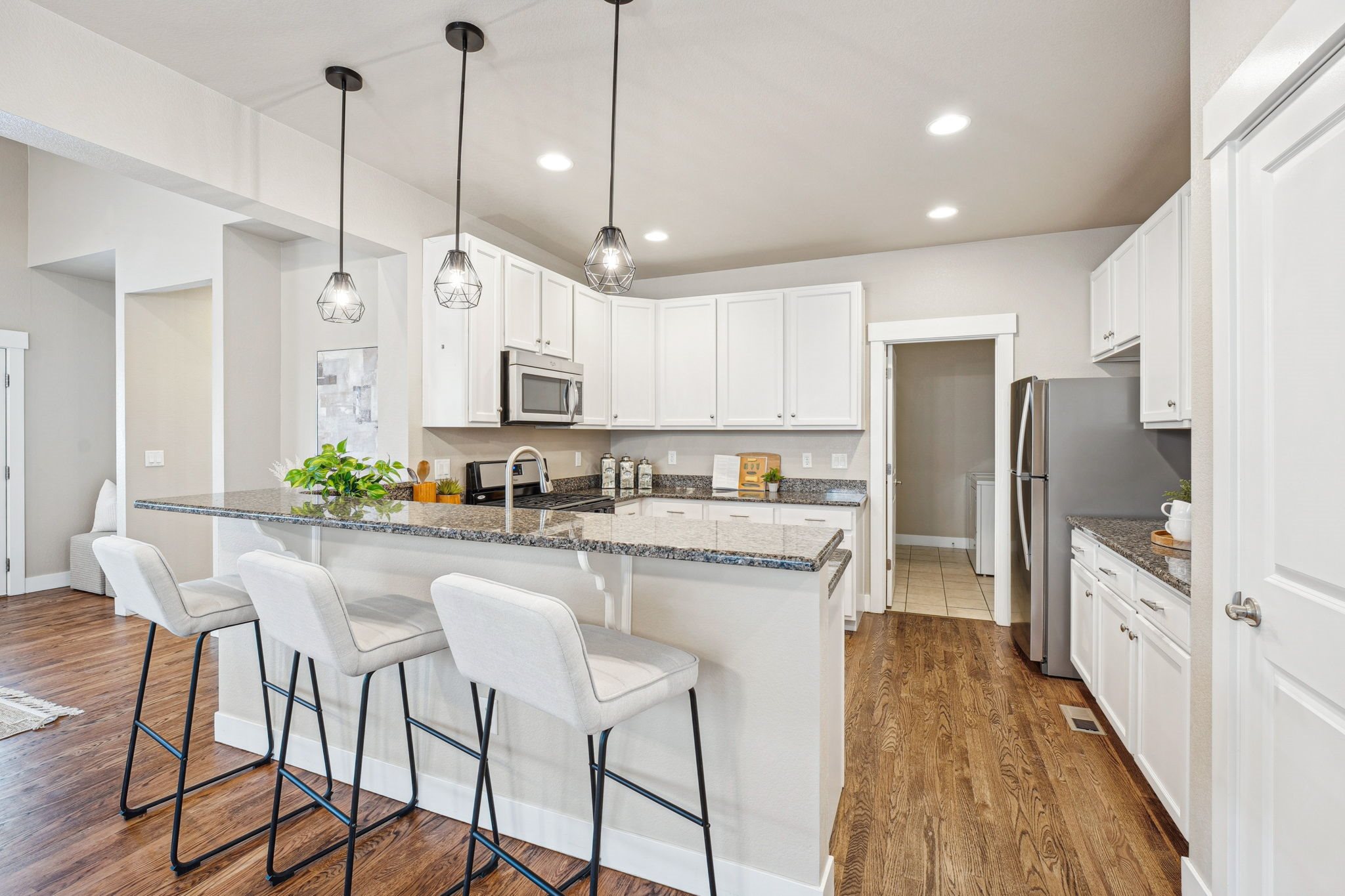A kitchen with white cabinets and a granite countertop.