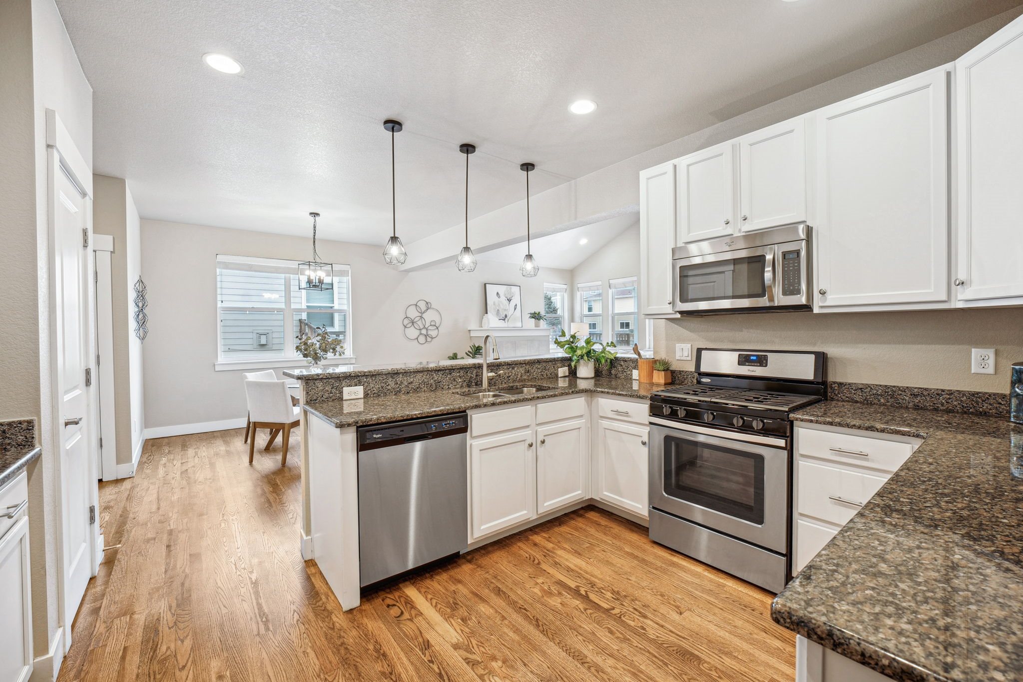 A kitchen with white cabinets and granite countertops.