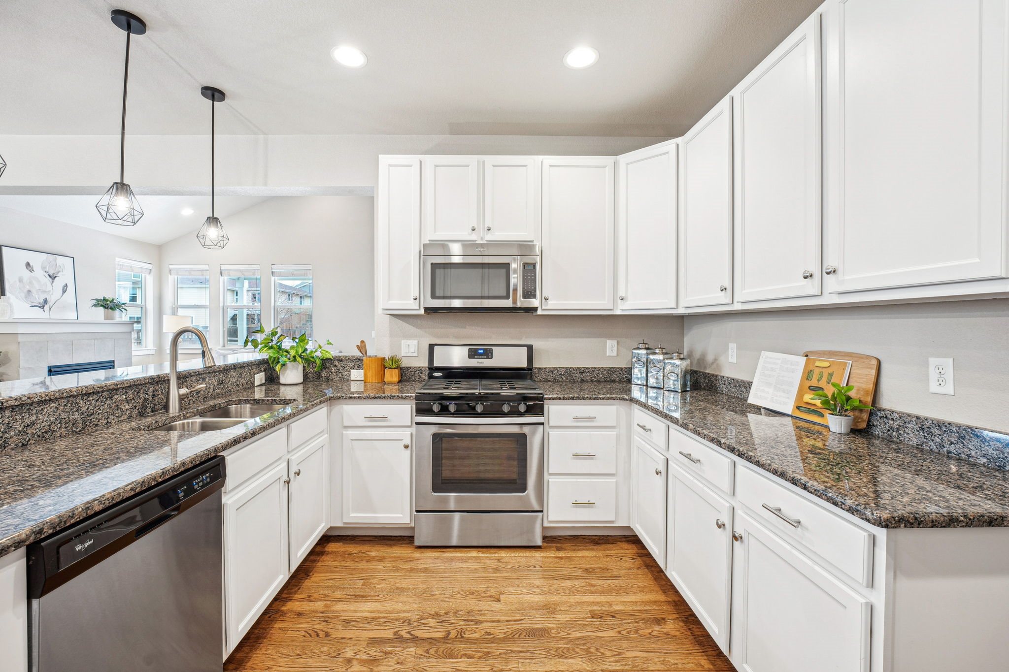 A kitchen with white cabinets and a granite countertop.