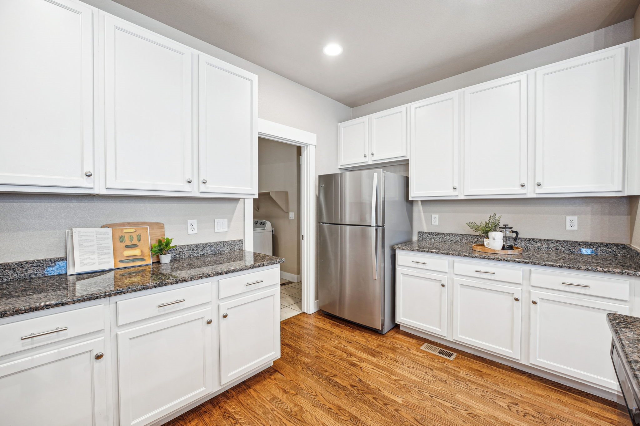 A kitchen with white cabinets and a granite countertop.