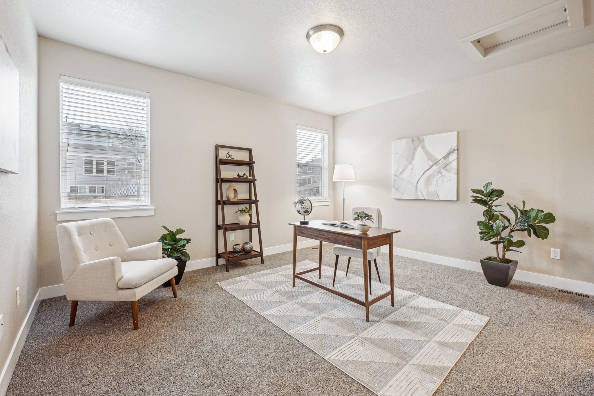 A room with a chair, a table, and a potted plant.