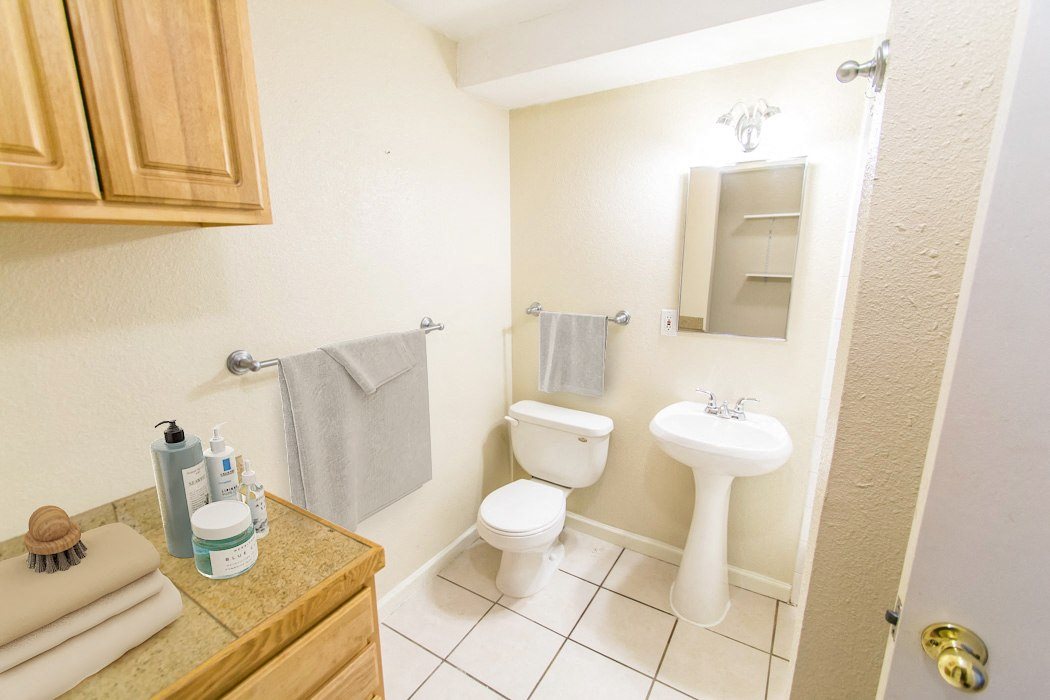 A bathroom with a toilet, sink, and towel rack.