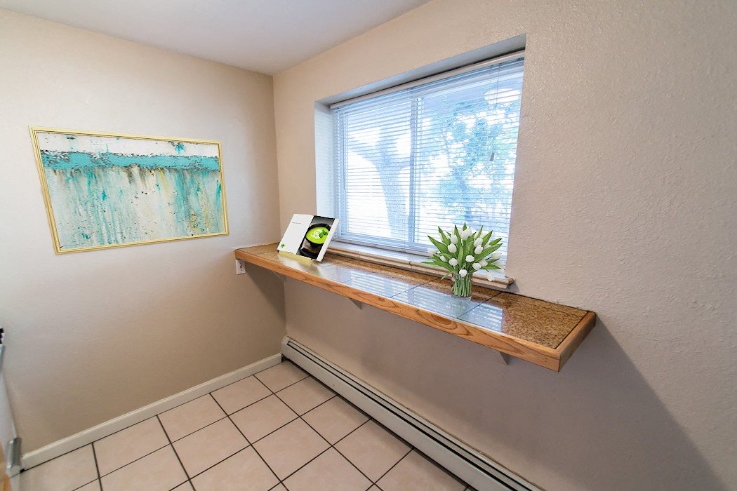 A room with a window seat and a painting on the wall.