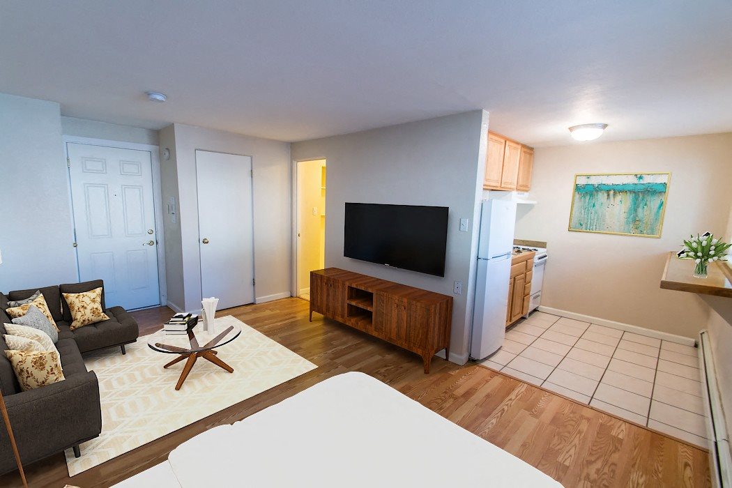 A living room with a couch, a coffee table, and a television.