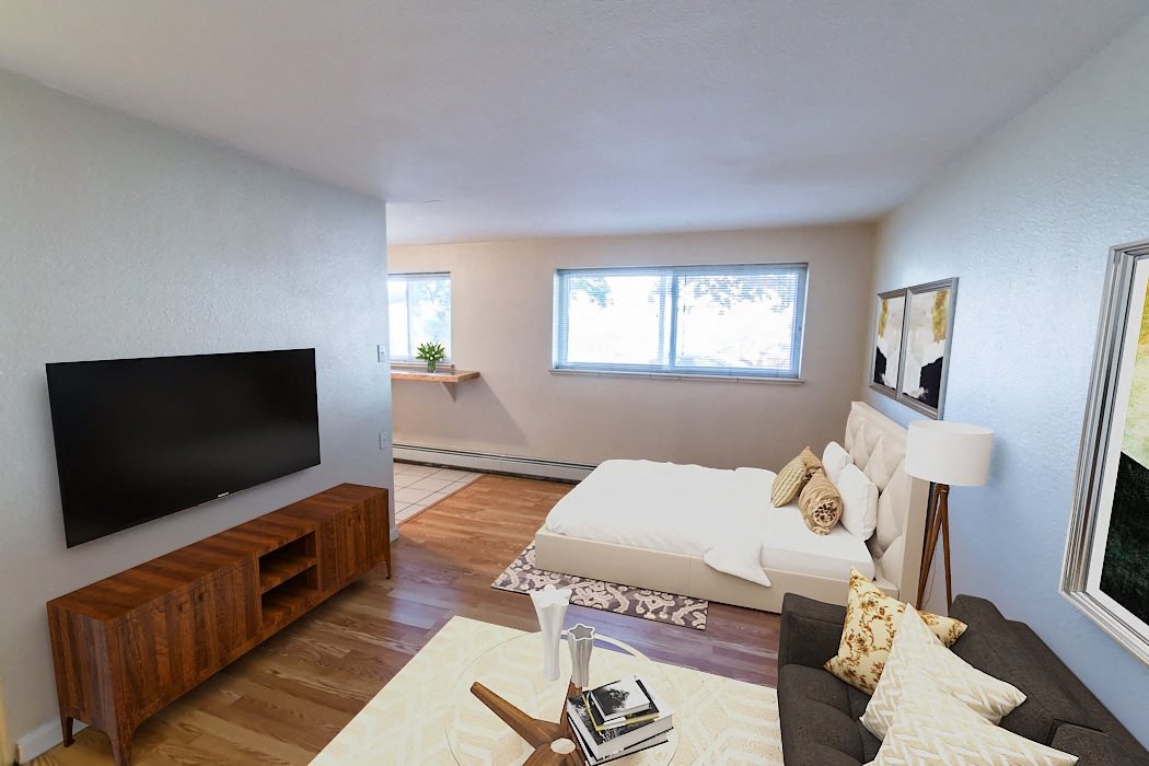 A living room with a white couch and a wooden entertainment center.