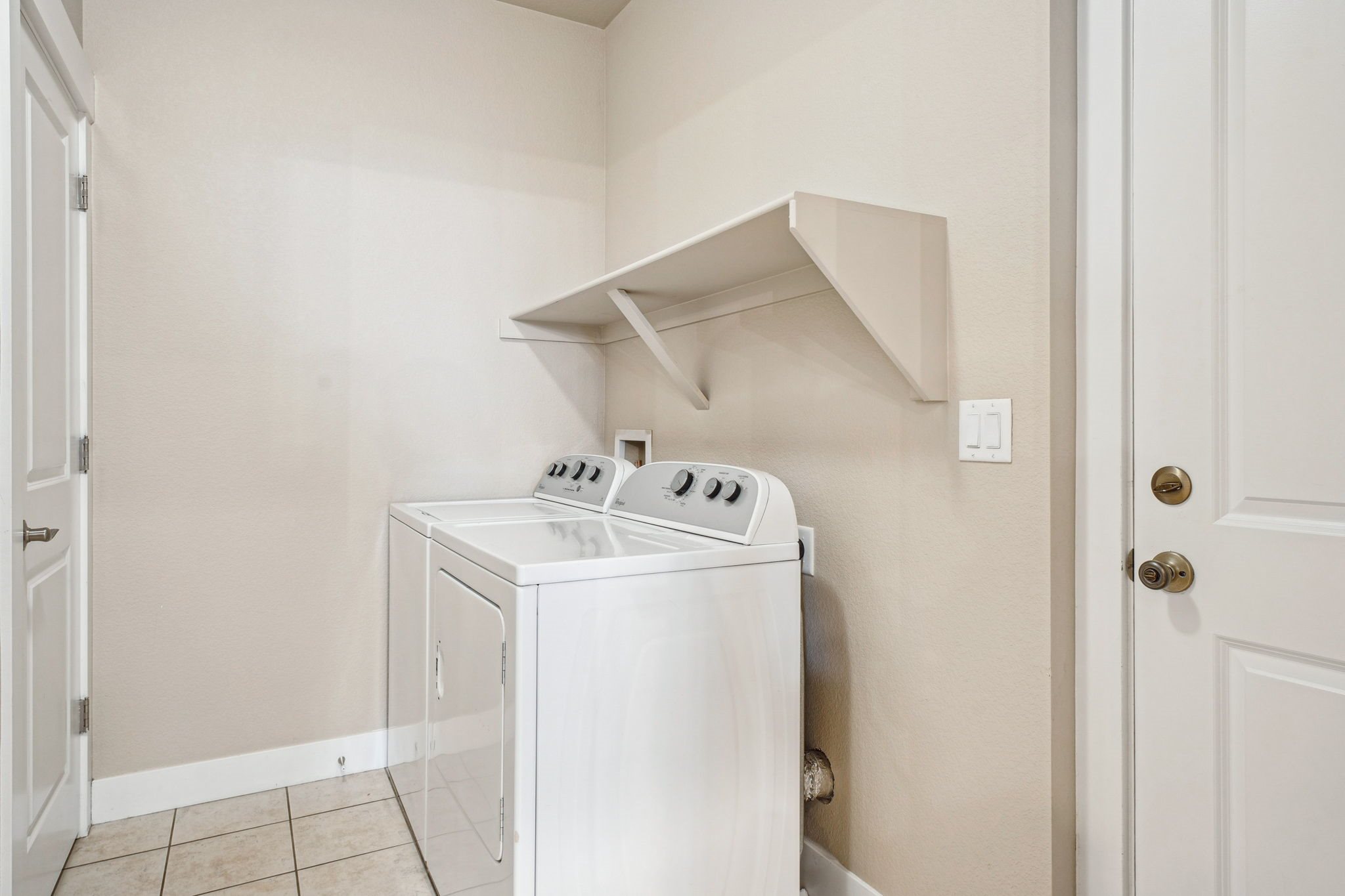 A white washing machine in a small laundry room.