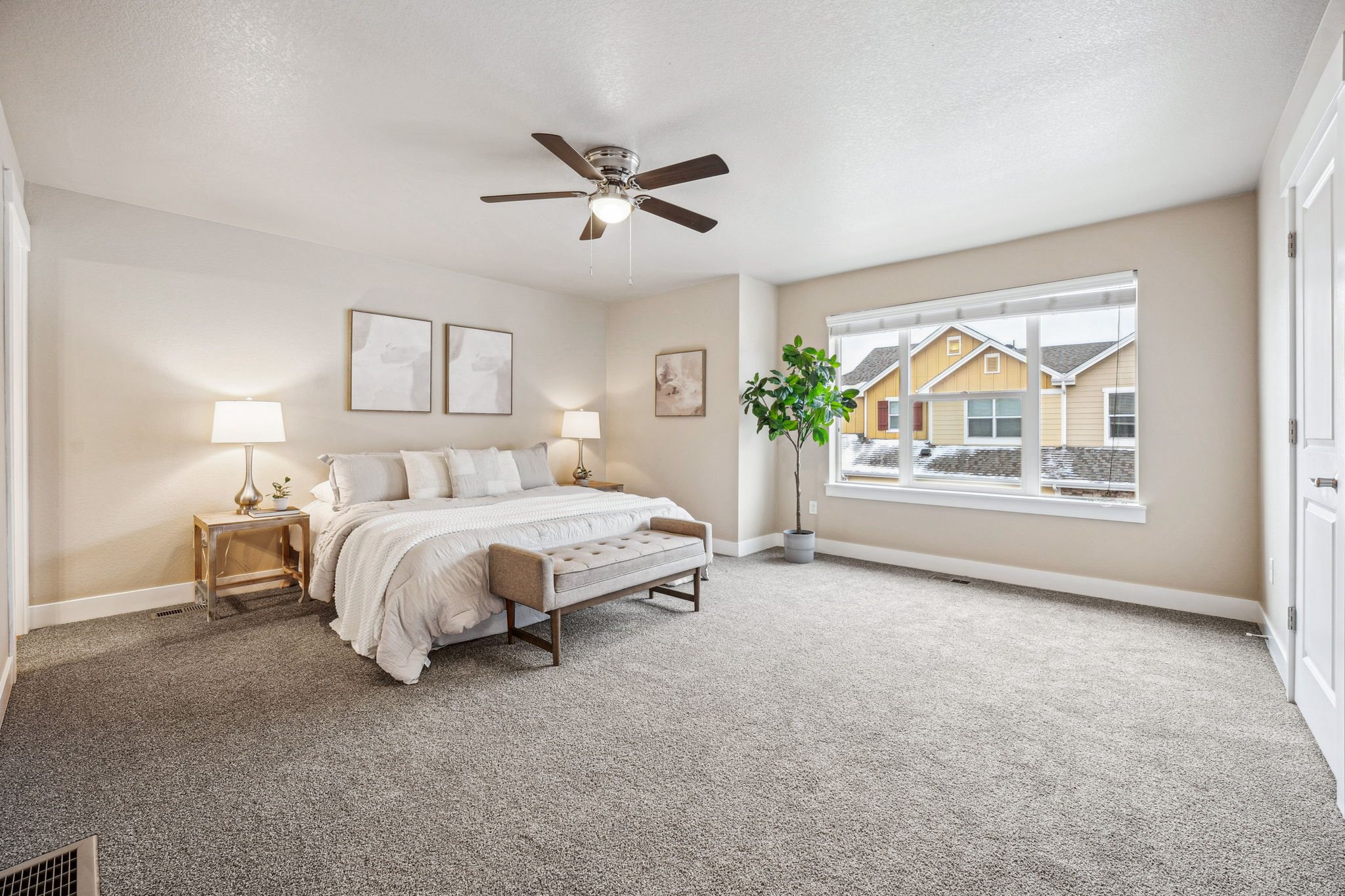 A bedroom with a bed, nightstands, and a ceiling fan.