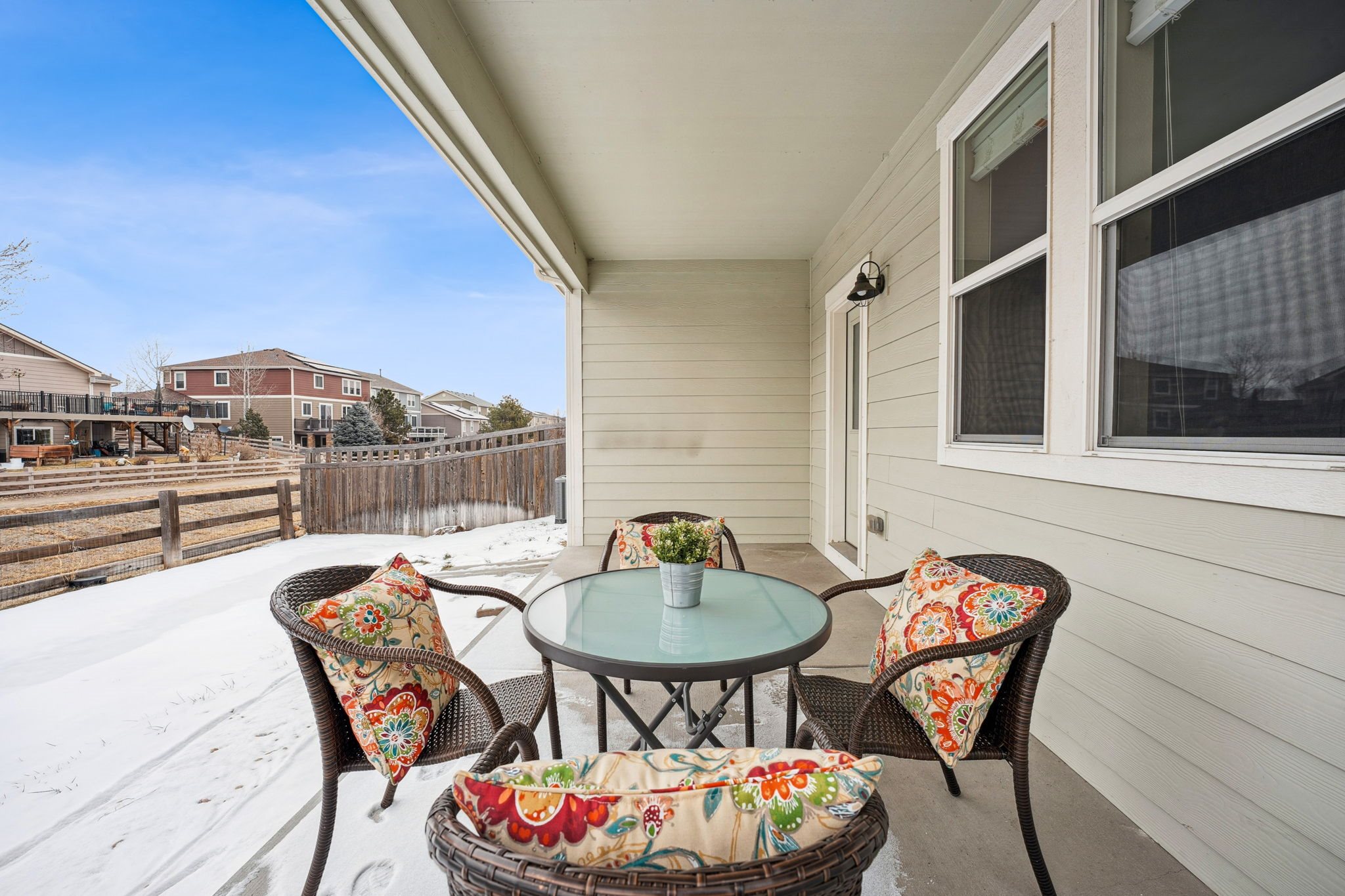 A patio with a table and chairs covered in snow.