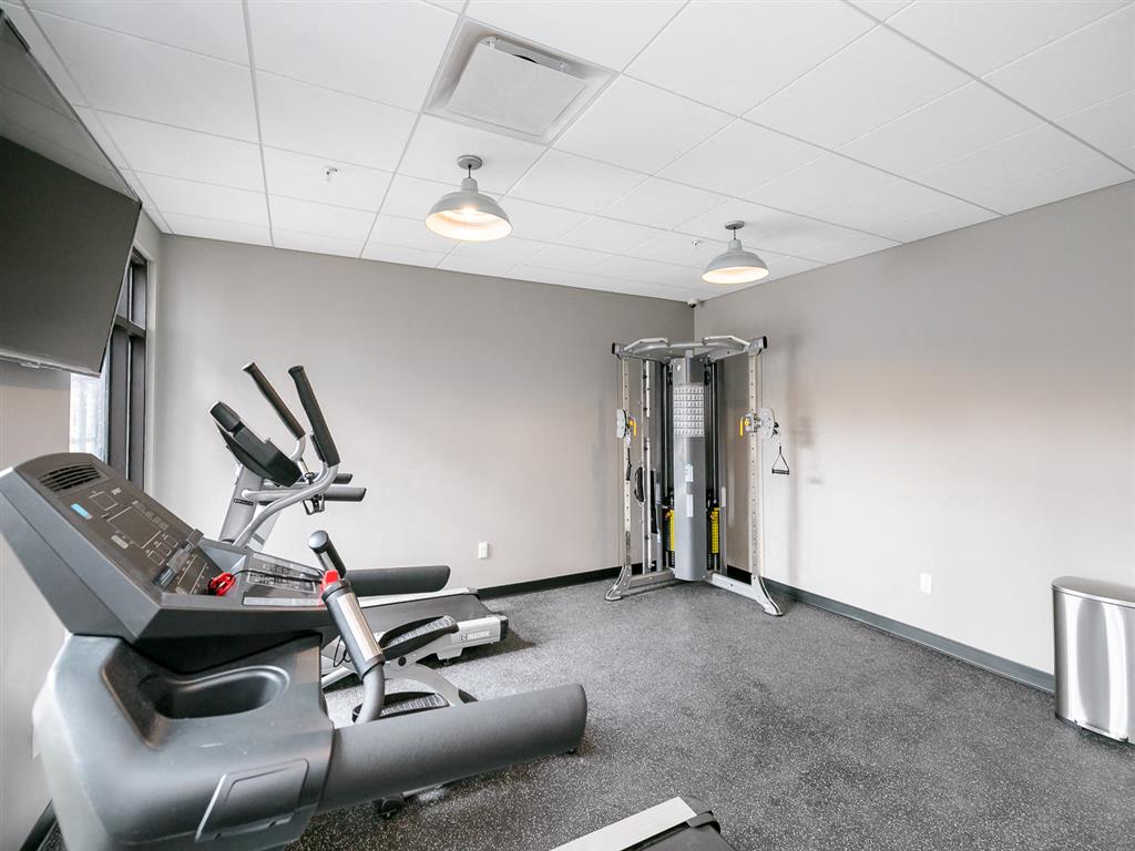 a gym with a treadmill and weights in it