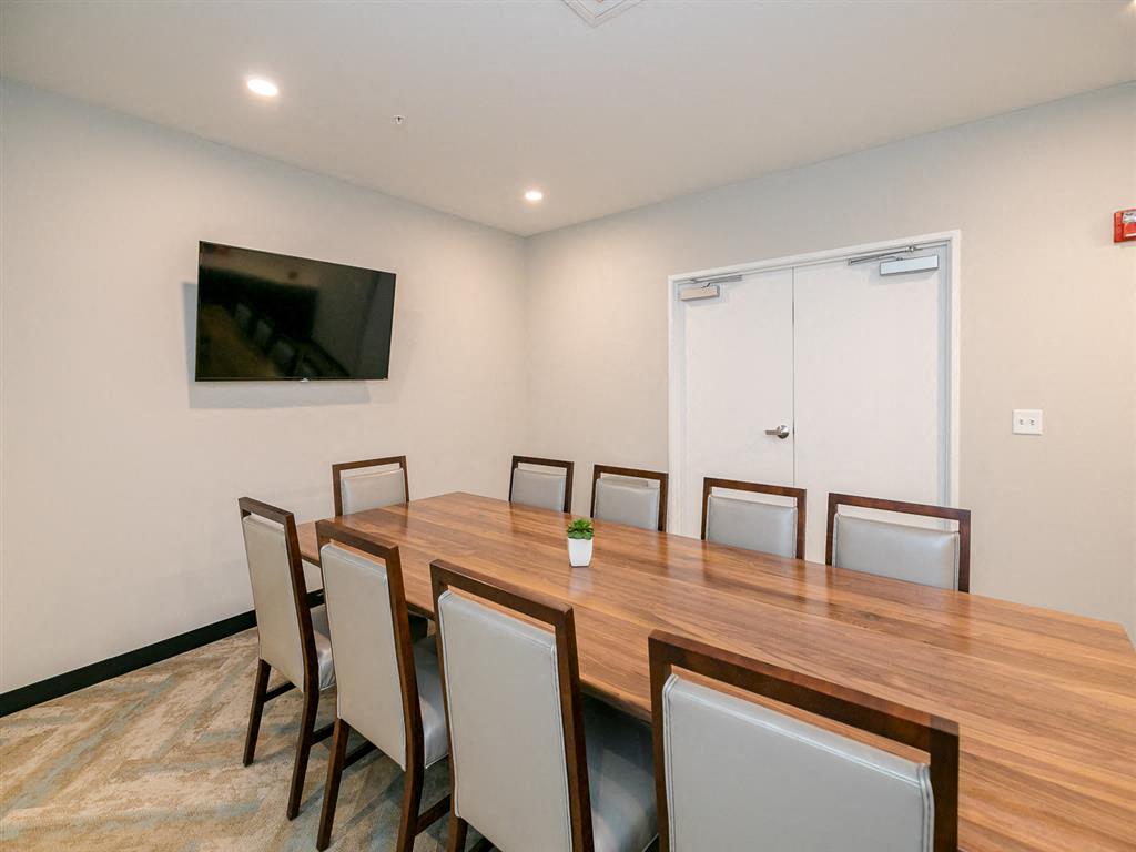 a conference room with a table and chairs and a flat screen tv on the wall