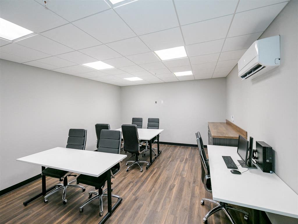 a small conference room with desks and chairs