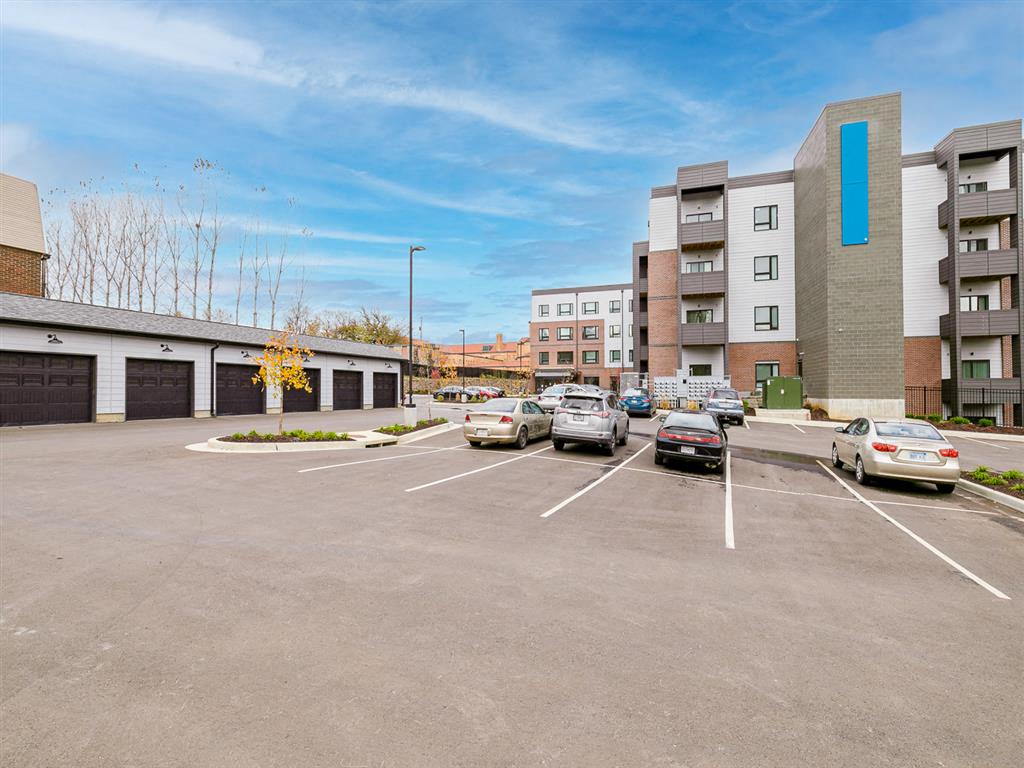 a parking lot with cars and buildings in the background