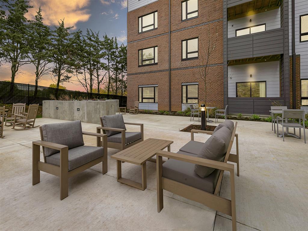a patio with furniture and a fire pit at the district flats apartments in lenexa,