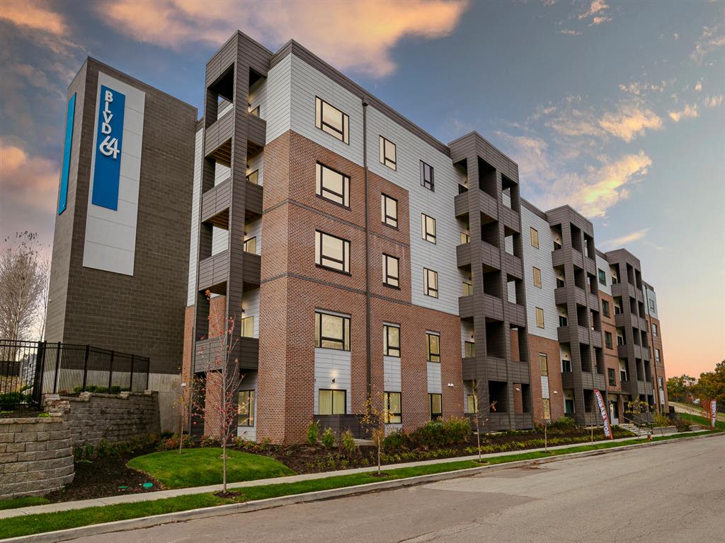 picture of an apartment building with a street in front of it