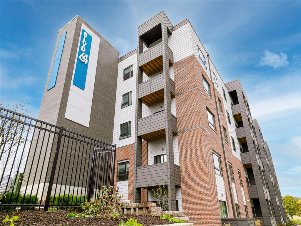 a picture of a large apartment building with a blue sign on the side of it