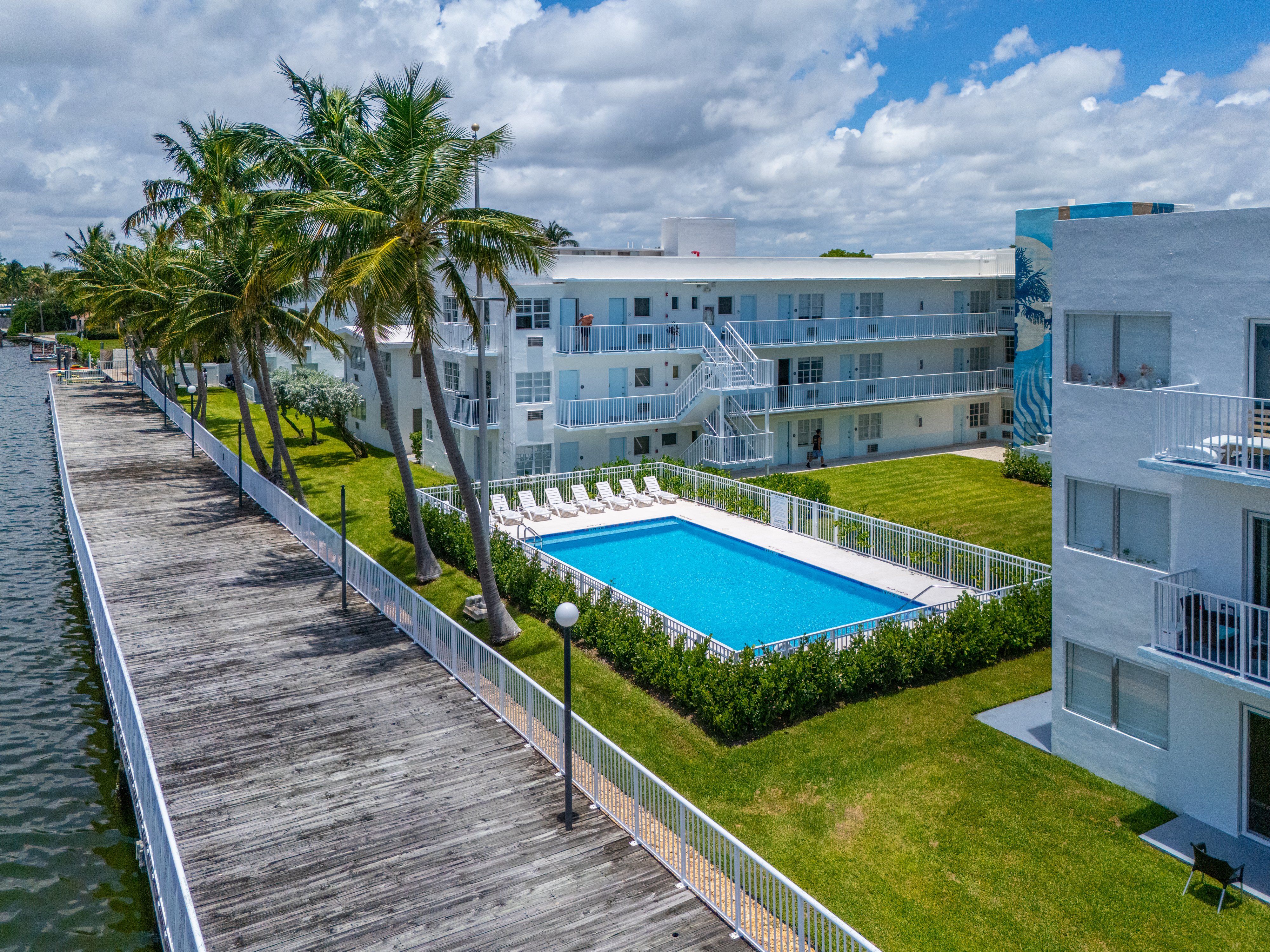 view of pool and apartment buildings with palm trees